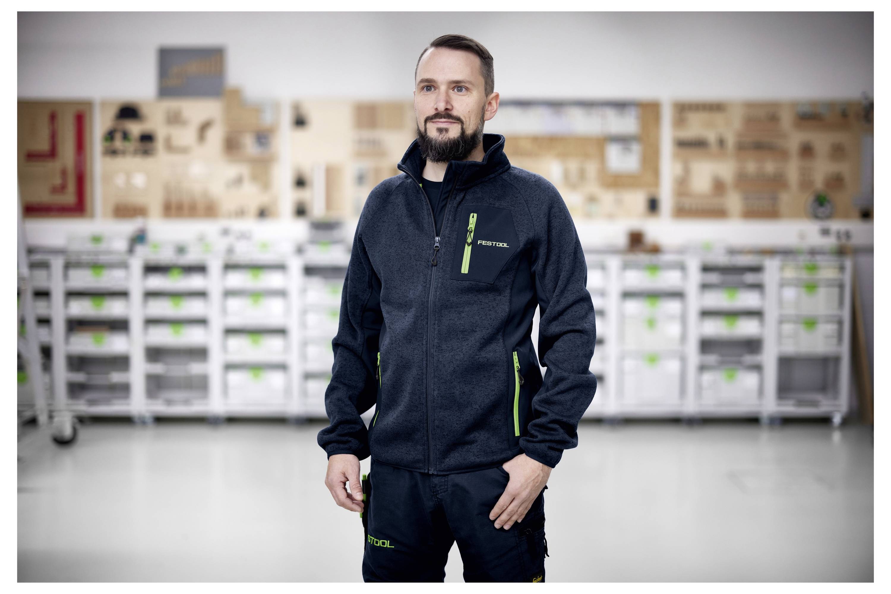 Eine Frau organisiert Lagerbehälter in einem Van mit Regalen und verschiedenen Werkzeugen, was auf eine mobile Arbeits- oder Serviceeinrichtung hindeutet.