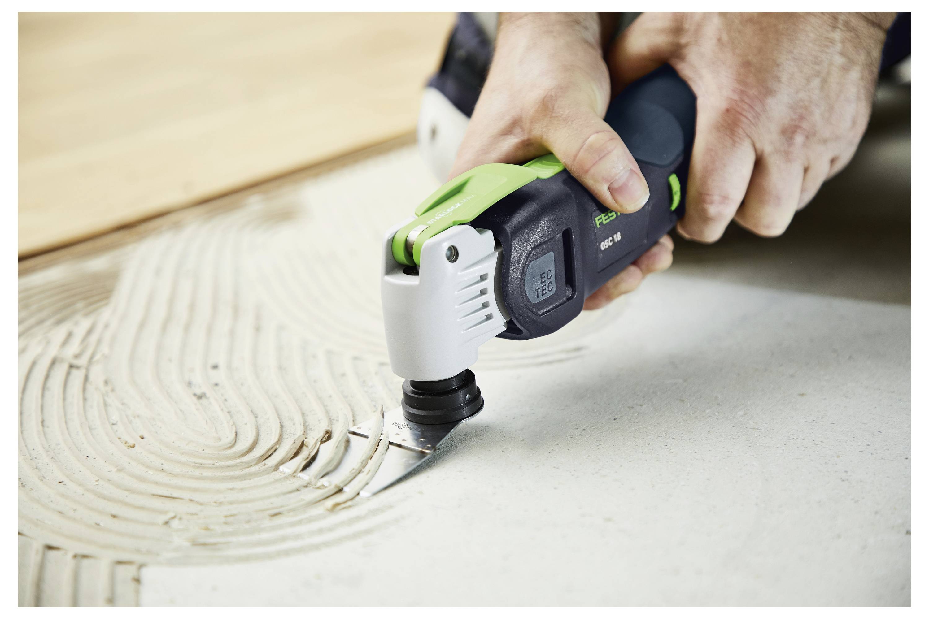 Eine Person benutzt einen tragbaren elektischen Schleiffer, um die Kante eines Holztreppengeländers zu glätten.