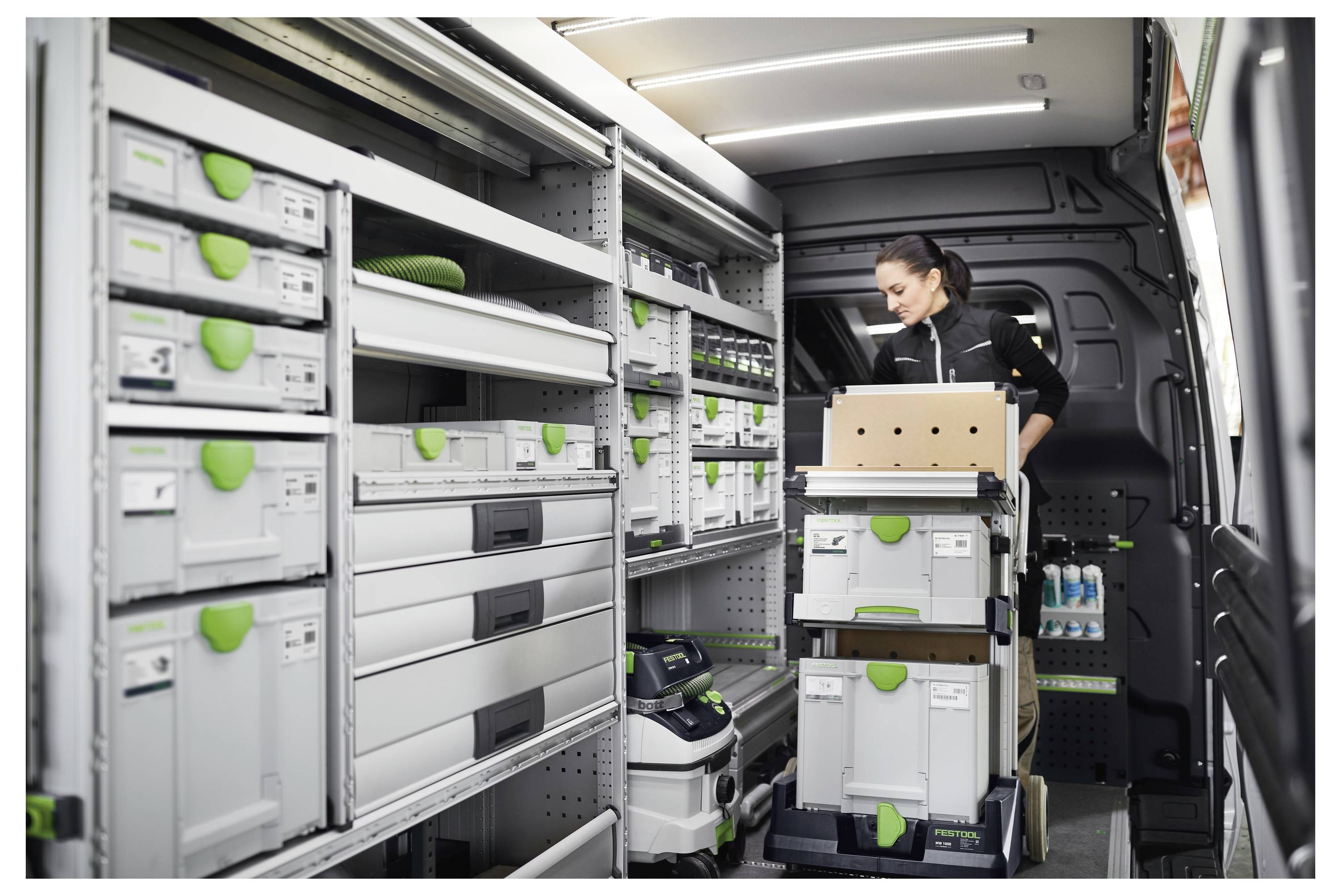 Das Aufhängungssystem eines Autos mit Fokus auf eine Strebe, die mit einem Schraubenschlüssel angezogen wird, was Reparatur- oder Wartungsarbeiten veranschaulicht.