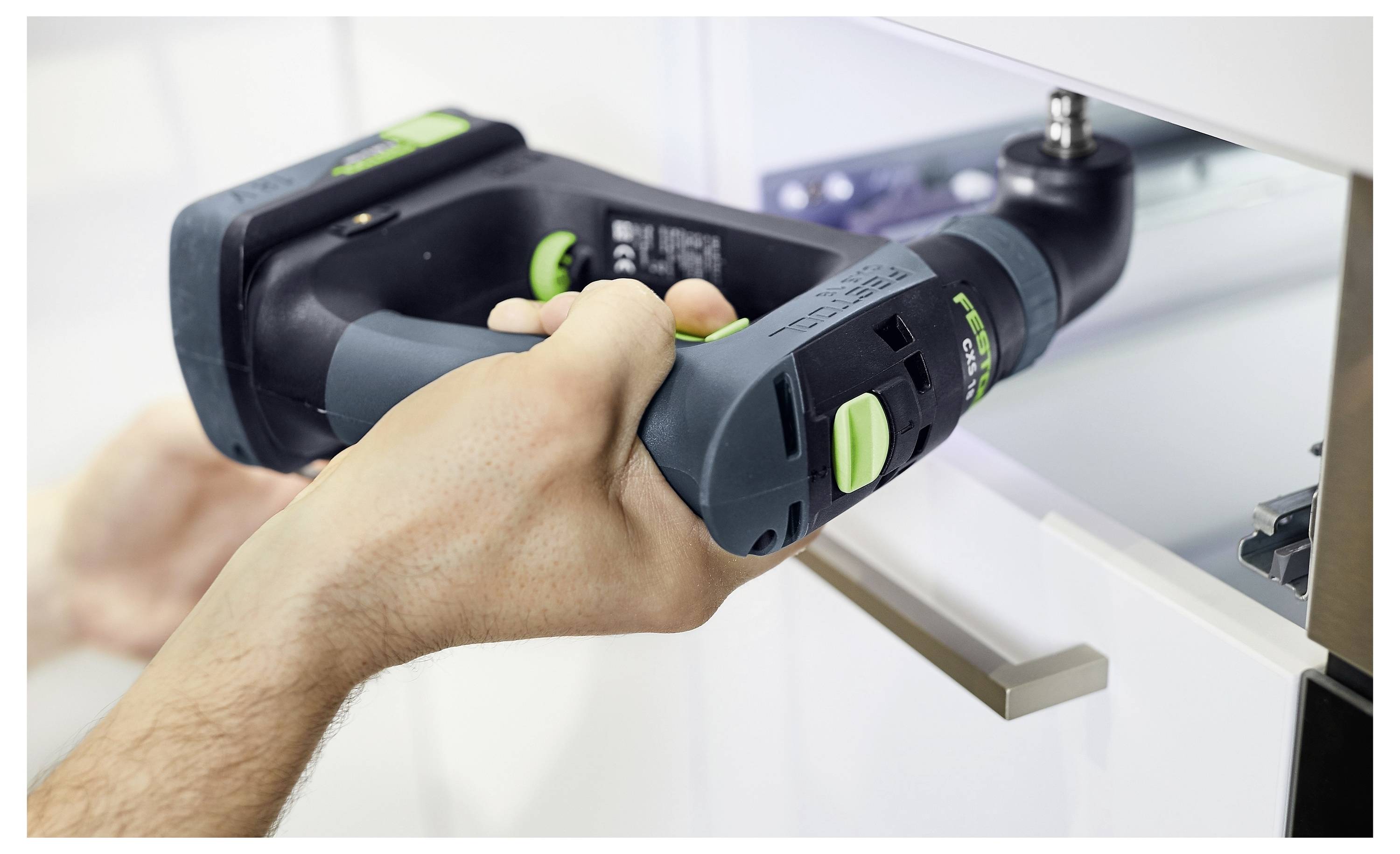 Eine Person lädt Ausrüstung mit einem Wagen in die Rückseite eines Lieferwagens, der mit Regalen und Vorräten organisiert ist. Der Ort ist eine Innengaragenwerkstatt.