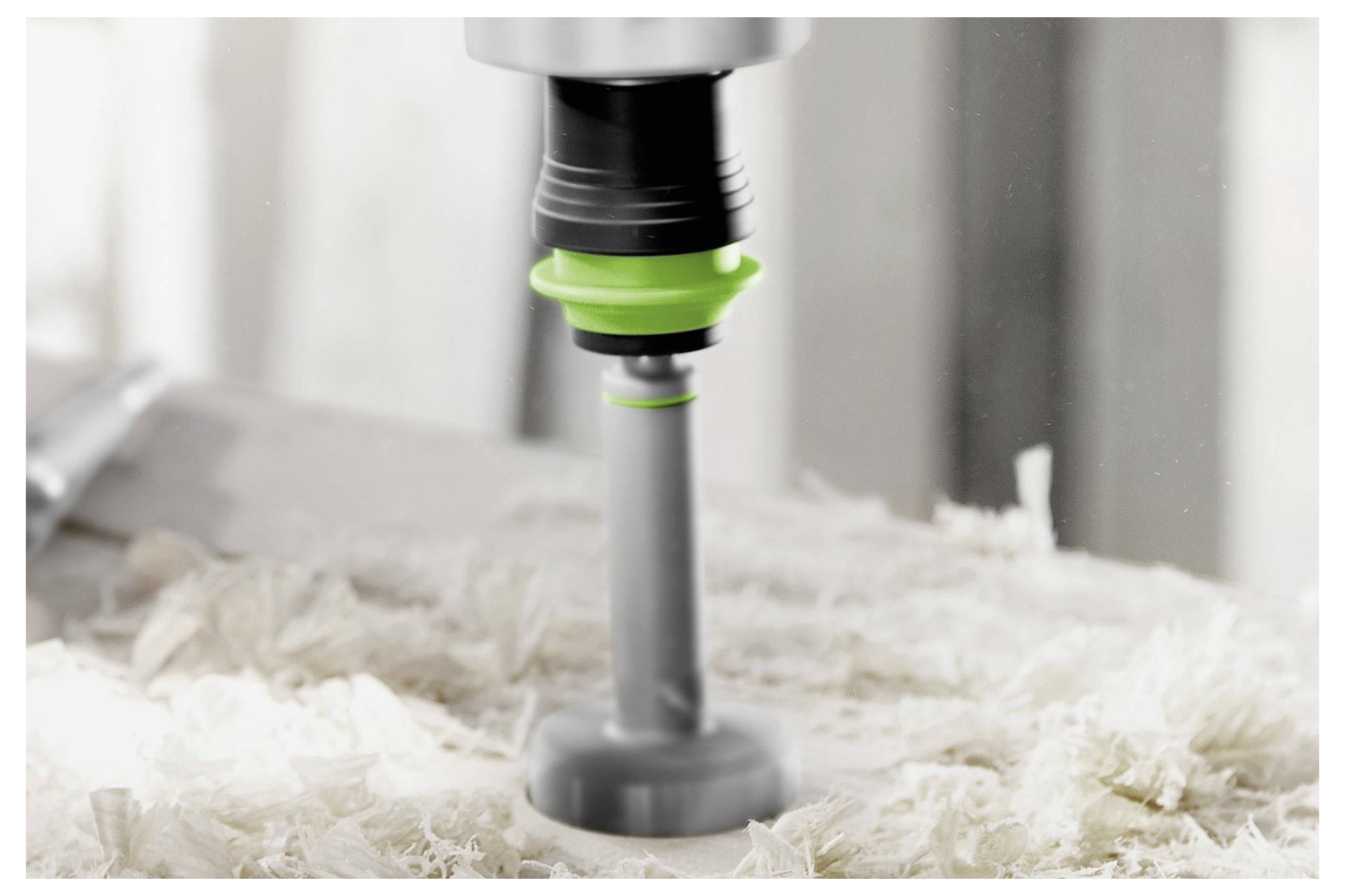 Ein in Gebrauch befindlicher Bohrer erzeugt Holzspäne und verdeutlicht damit Holzbearbeitungs- oder Bauaktivitäten.