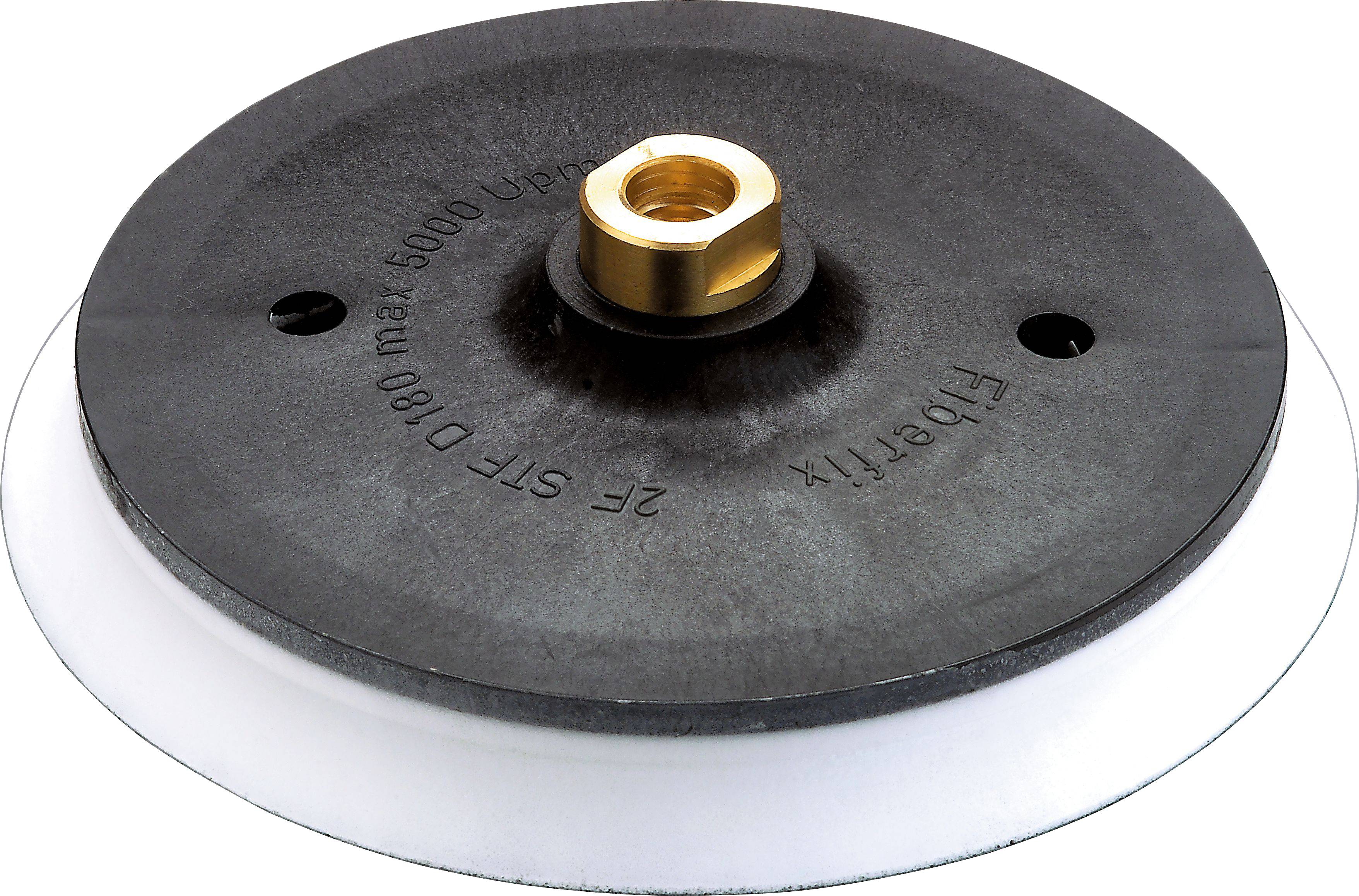 Eine schwarze kreisförmige Scheibe mit einer zentralen Messingarmatur und dem eingraviertem Text 'max 5000 U/min, D 180, 2F Str'.
