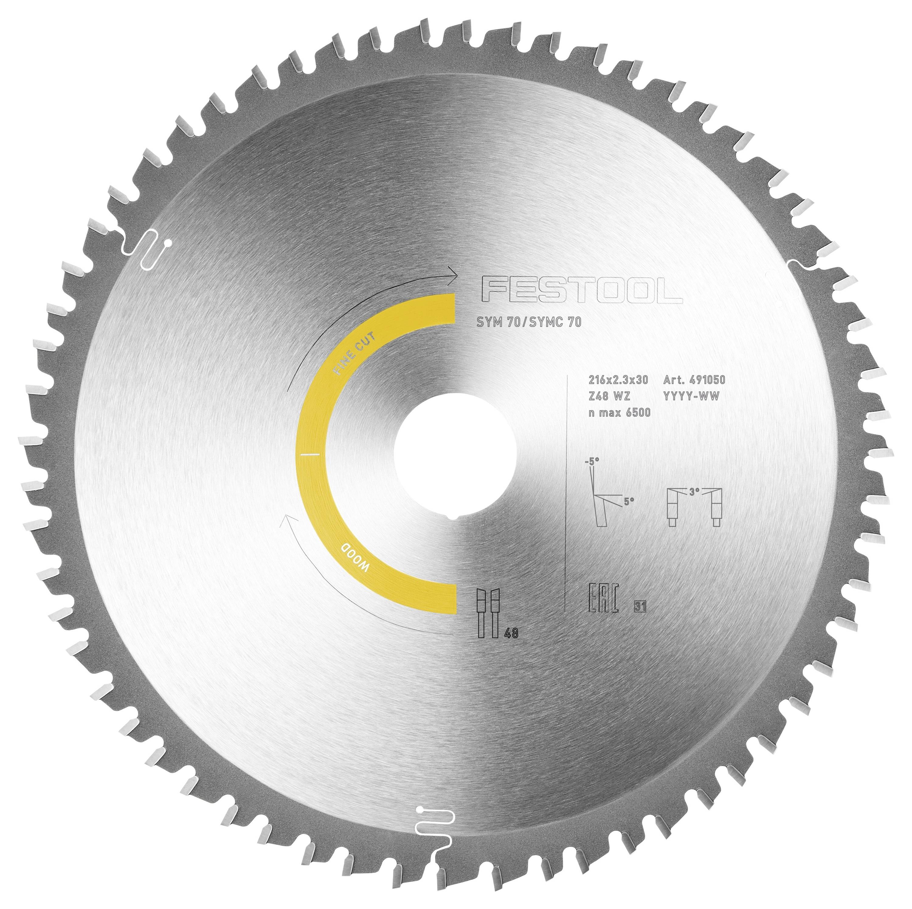 Ein Mann in einem schwarzen Poloshirt und Shorts steht lächelnd vor gestapelten Holzbrettern in einer Werkstatt.