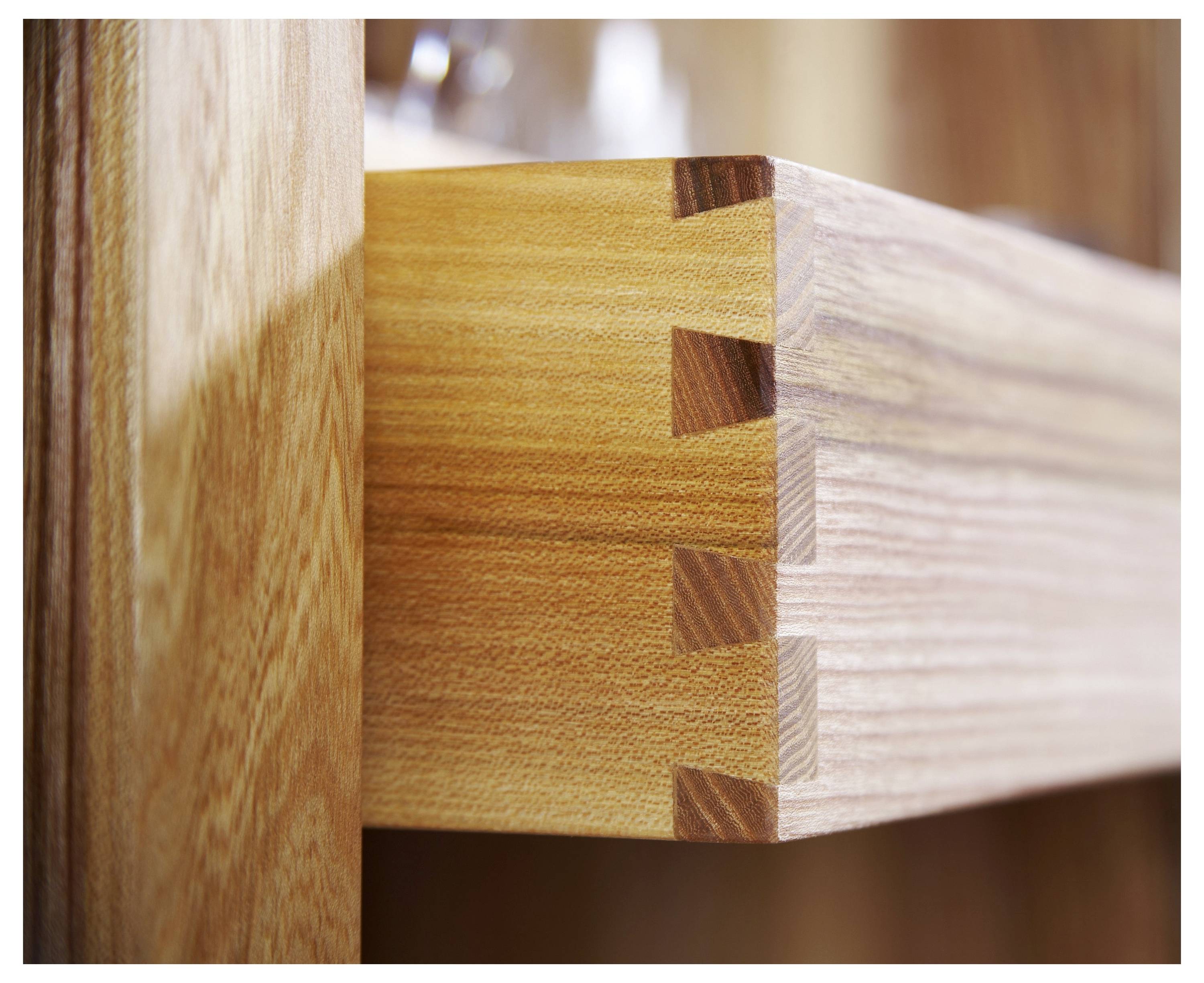 Eine Nahaufnahme einer hölzernen Schwalbenschwanzverbindung, die das präzise ineinandergreifende Design der Holzbretter hervorhebt.