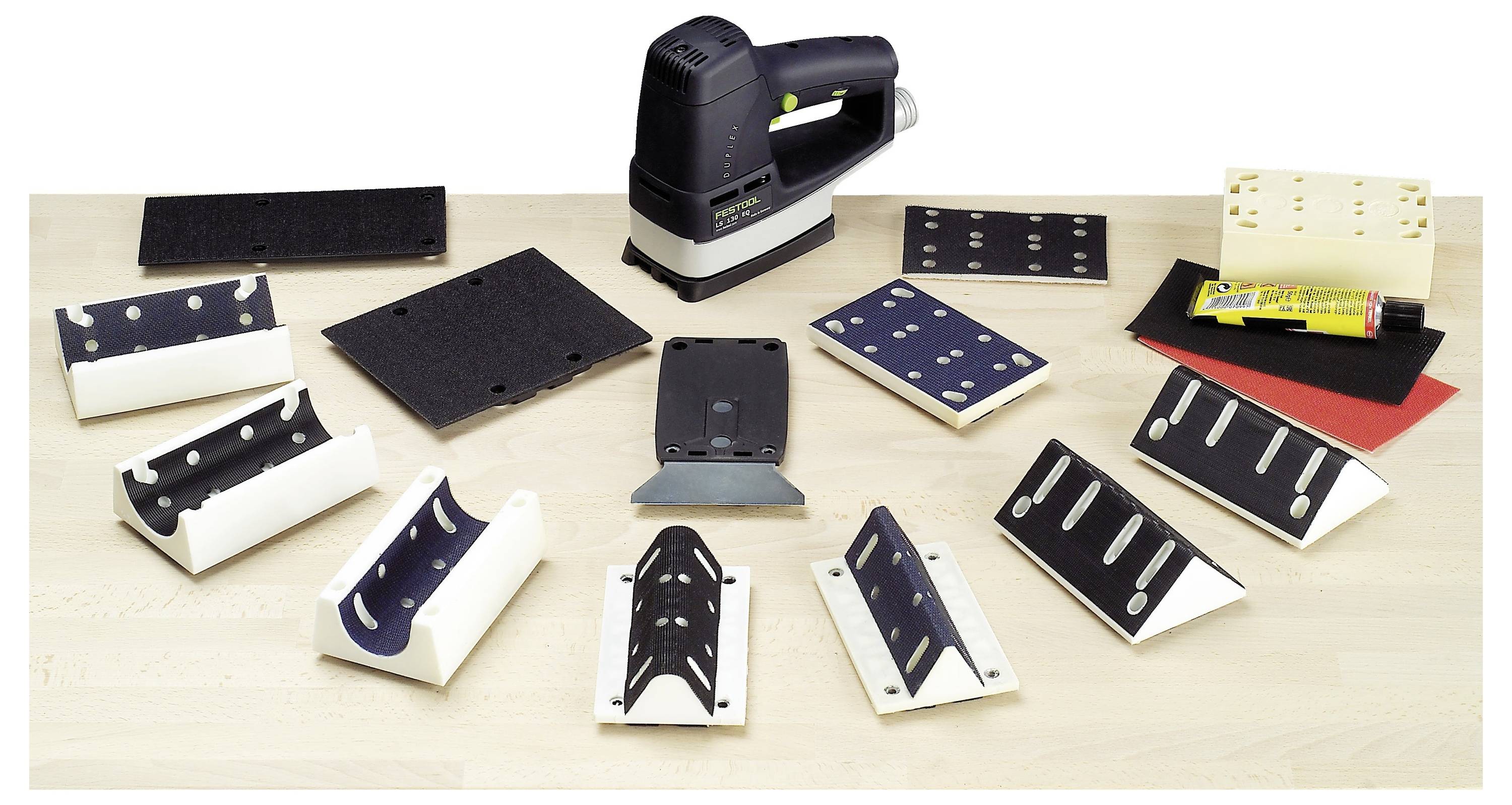 Sammlung von Schleifwerkzeugen und Zubehör, einschließlich eines Elektroschleifers, Schleifpads und Schleifpapier, angeordnet auf einem Holztisch.