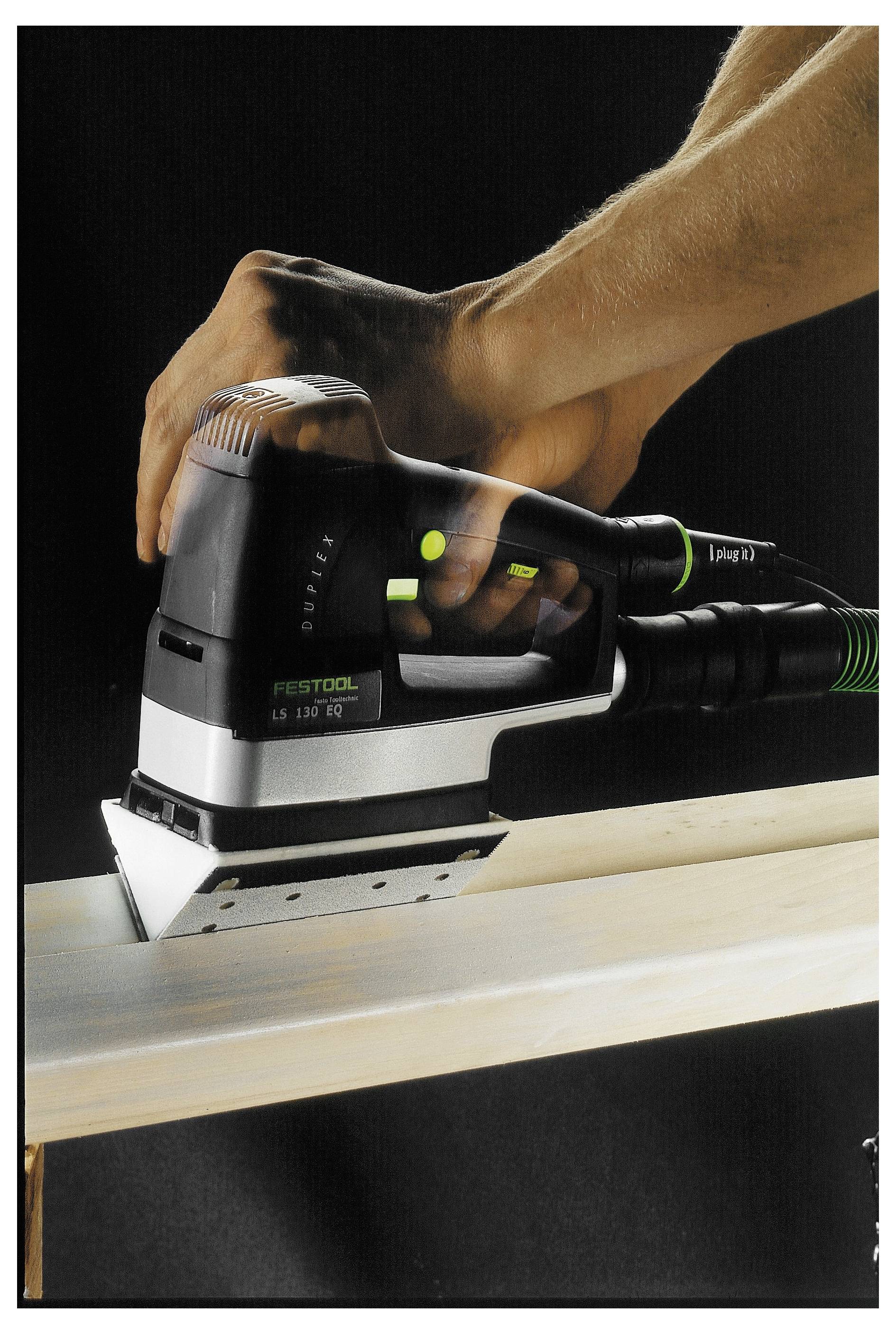 Eine Person nutzt einen Festool-Schleifer auf einem Holzbrett und glättet dessen Oberfläche. Das Bild konzentriert sich auf das Werkzeug und die Handbewegung.