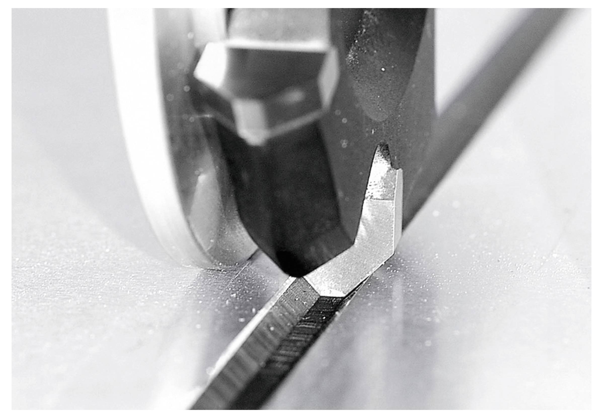 Nahaufnahme einer Kreissägeblatt, das auf einer Werkbank Metall durchtrennt.