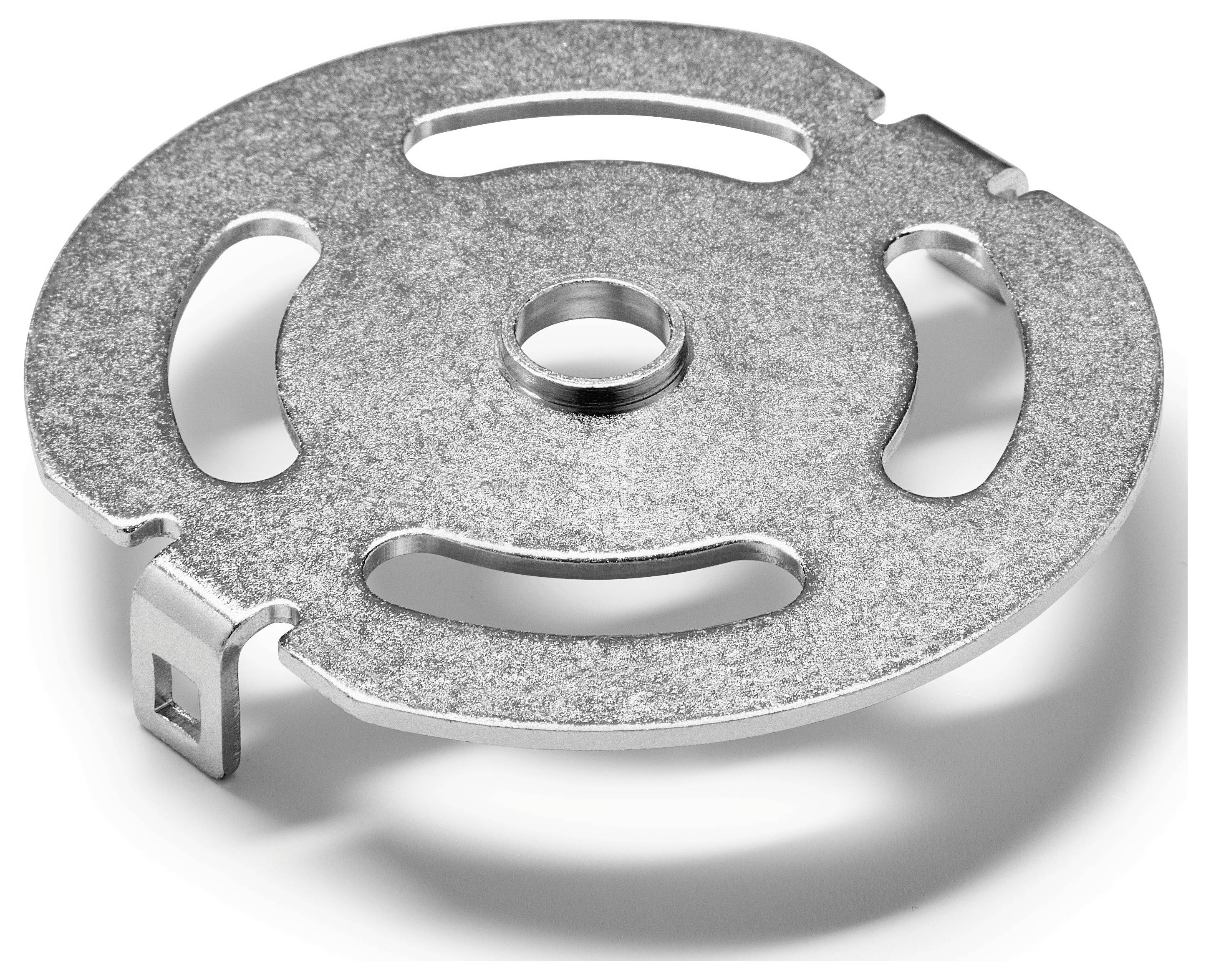 Ein Metallscheibe mit einem kreisförmigen Design, Schlitzen und einem zentralen Loch, möglicherweise eine mechanische Komponente, die auf einer weißen Oberfläche ruht.