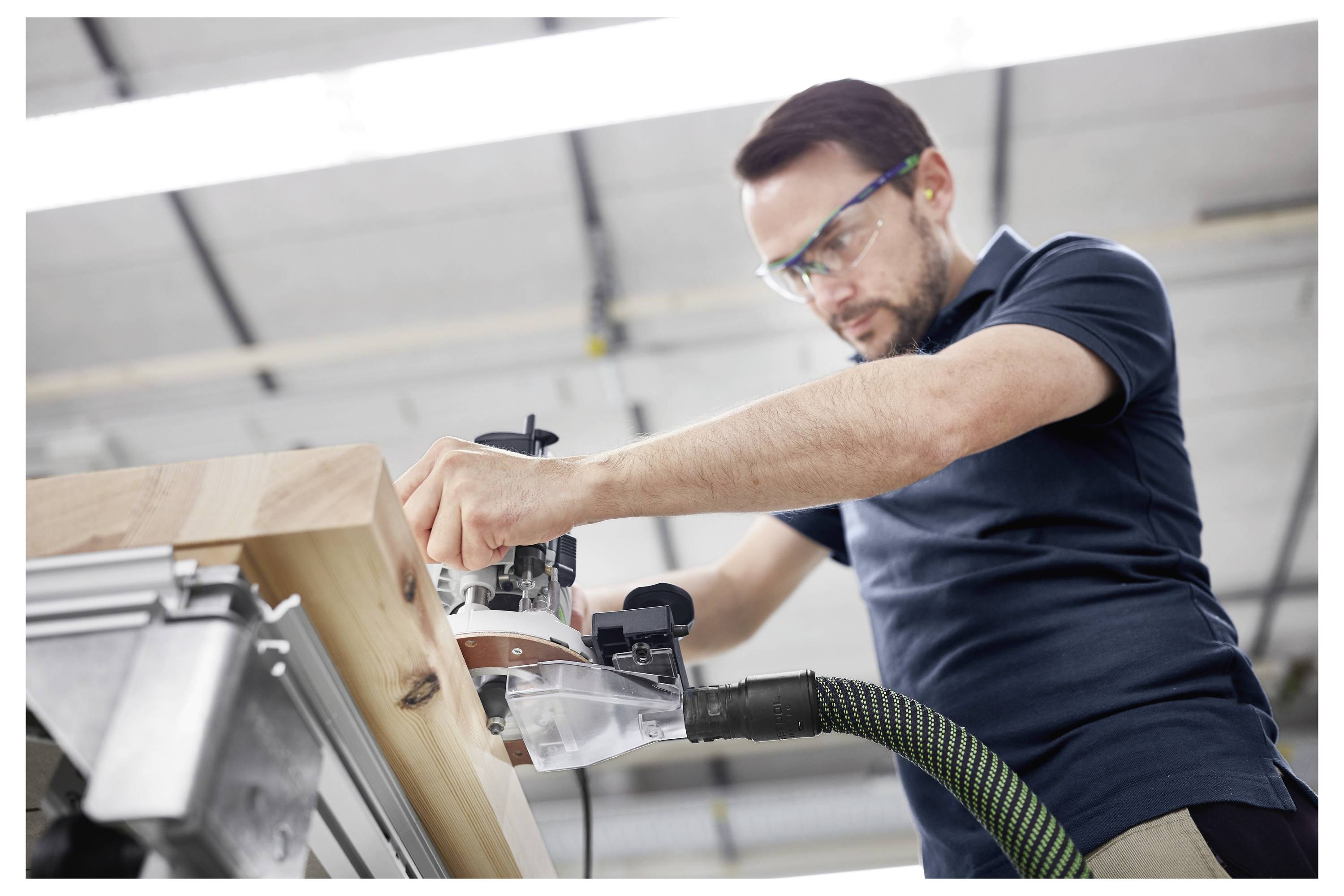 Eine Nahaufnahme eines Elektroschlüssels mit einem angebrachten Metallbohrer gegen einen unscharfen Hintergrund, was auf eine Werkstattumgebung hindeutet.