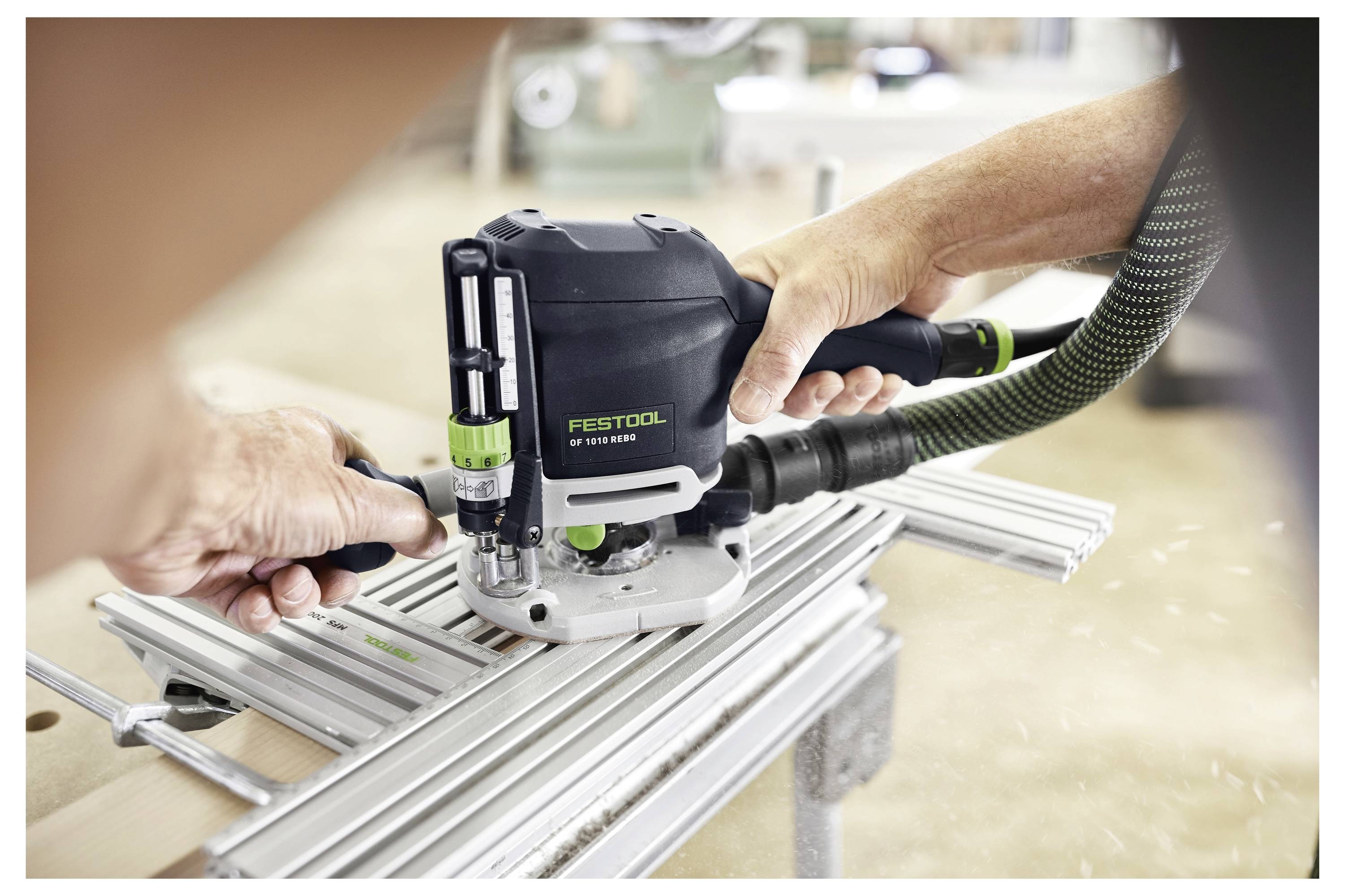 Eine Person bedient ein Elektrowerkzeug zum Fräsen von Nuten in eine Metalloberfläche, wobei Holzspäne auf einen aktiven Schneidvorgang hindeuten.