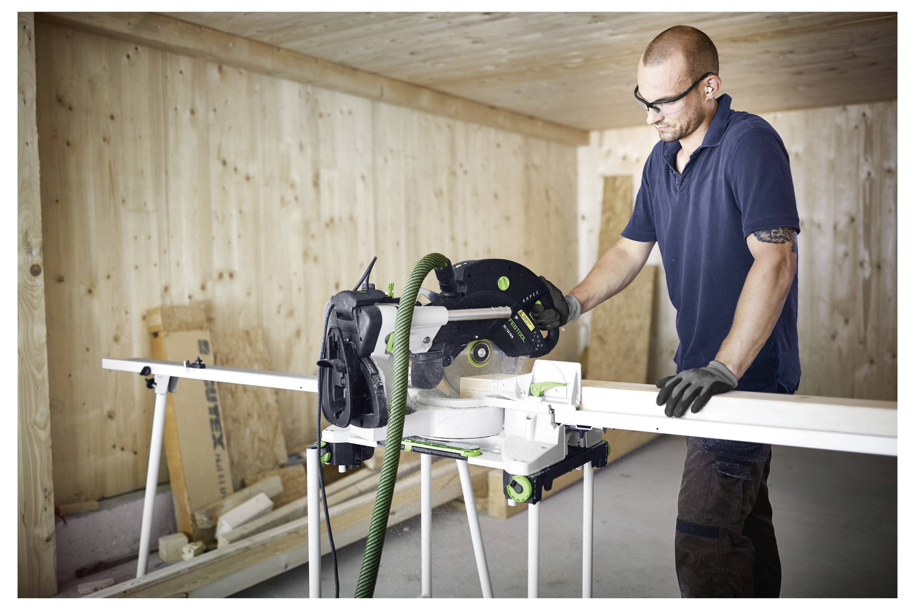 Eine Person verwendet einen Elektroschrauber, um ein Loch in eine Metalloberfläche zu bohren, mit unscharfem Werkstatt-Hintergrund.