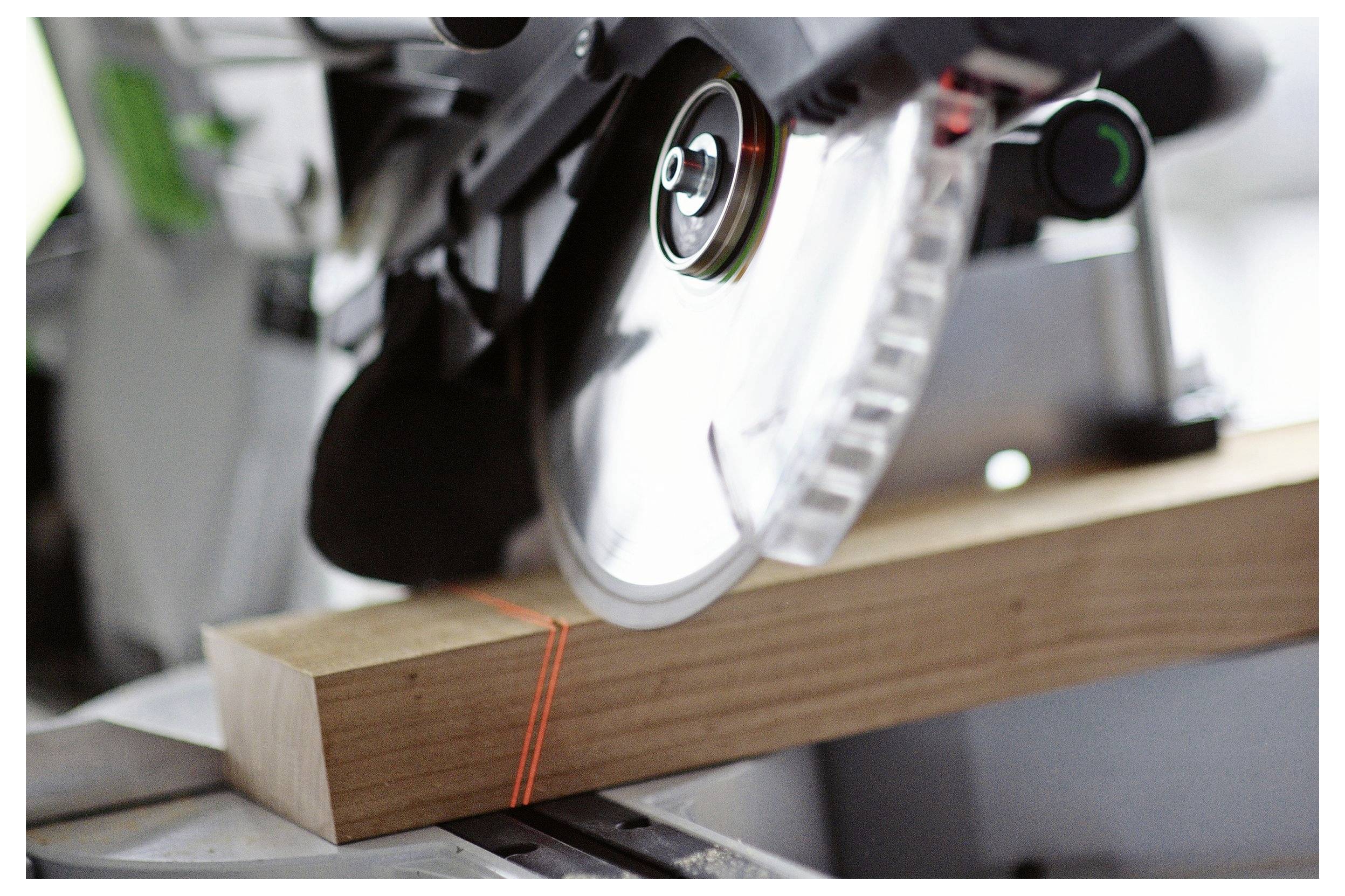 Eine Kreissäge schneidet durch einen Holzblock und zeigt Präzisions-Holzbearbeitungswerkzeuge in Gebrauch.