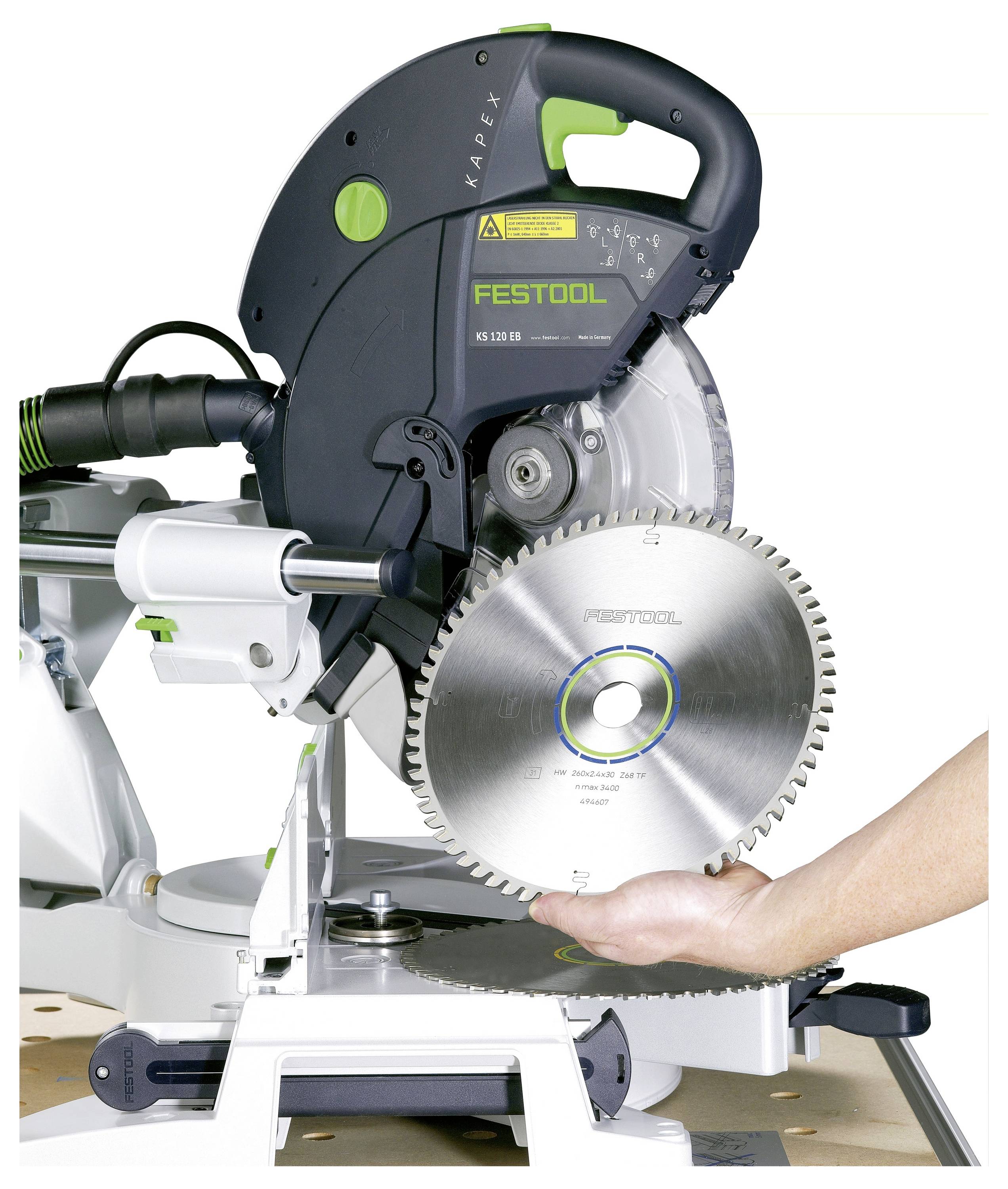 Eine Person, die ein Holzpuzzle zusammensetzt, richtet rechteckige Holzteile über einer gekrümmten, gezahnten Basis auf einer Werkbank aus.