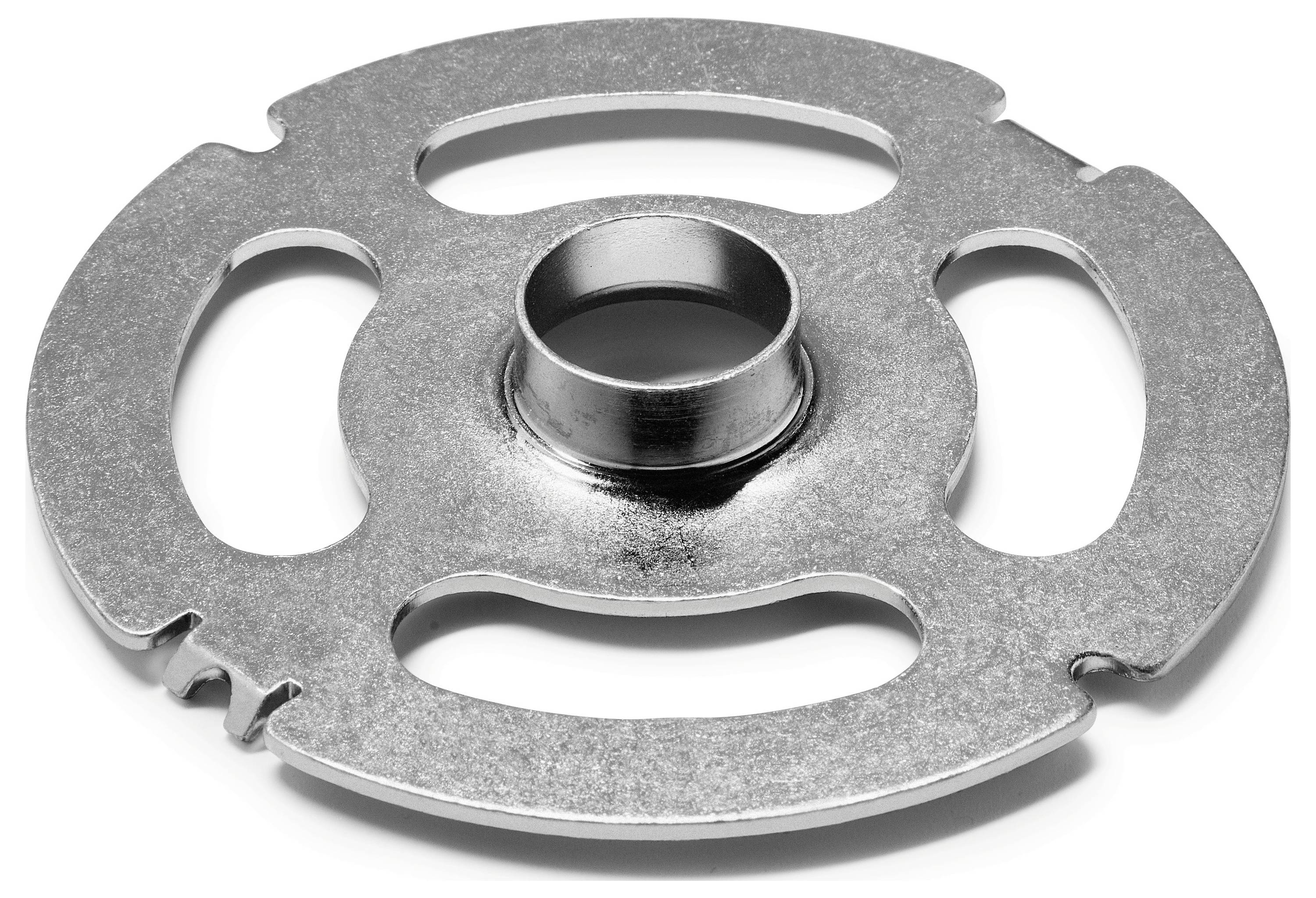 Eine runde Metallscheibe mit einem zentralen Loch, mit drei gekrümmten Ausschnitten und zahnradähnlichen Kerben am Rand, die an ein mechanisches Bauteil erinnert.