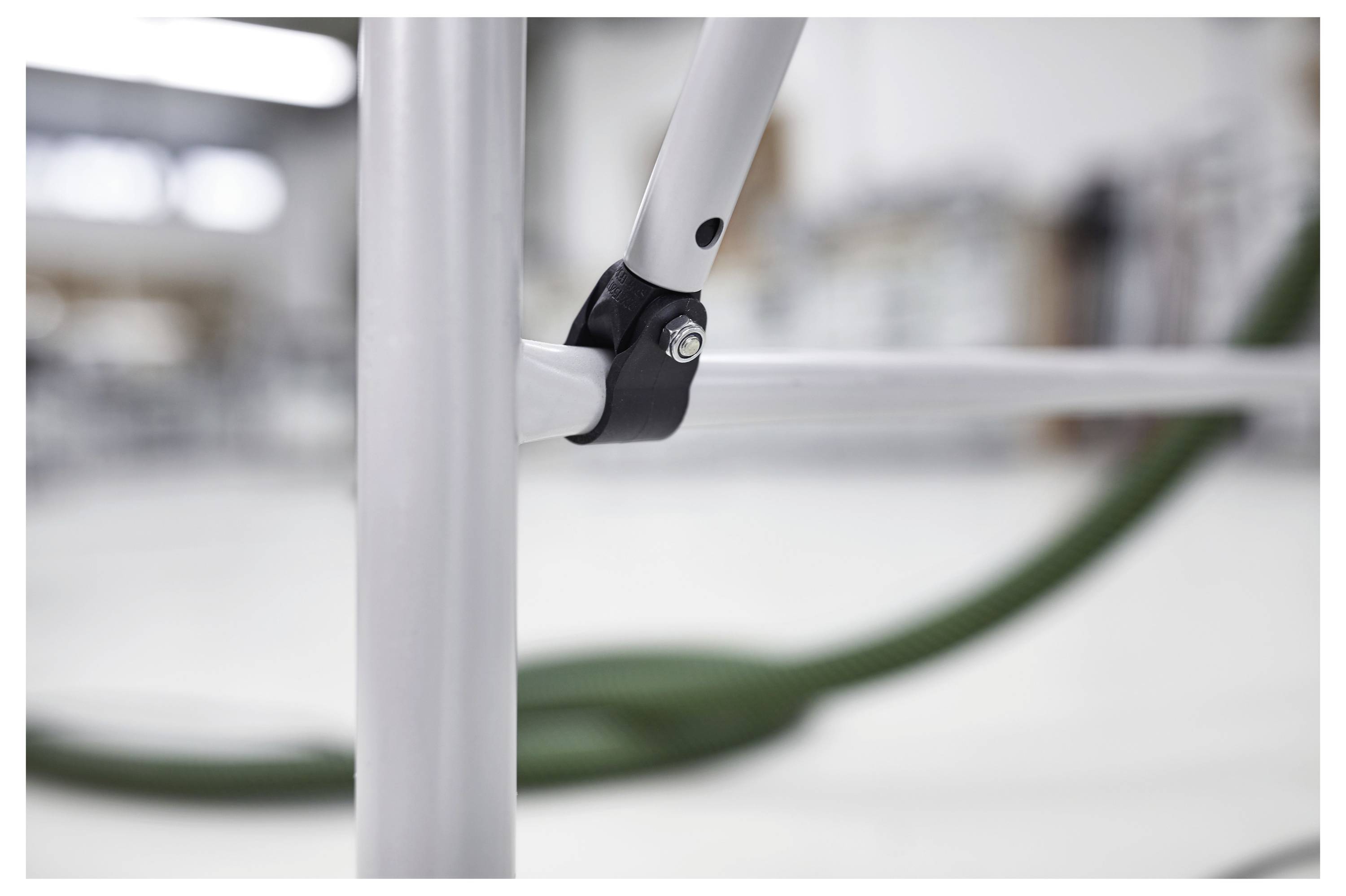 Hände halten einen Elektroschleiffer und glätten einen Holzfensterrahmen mit abgelöster Farbe. Ein Werkzeugkoffer ist im Hintergrund sichtbar.