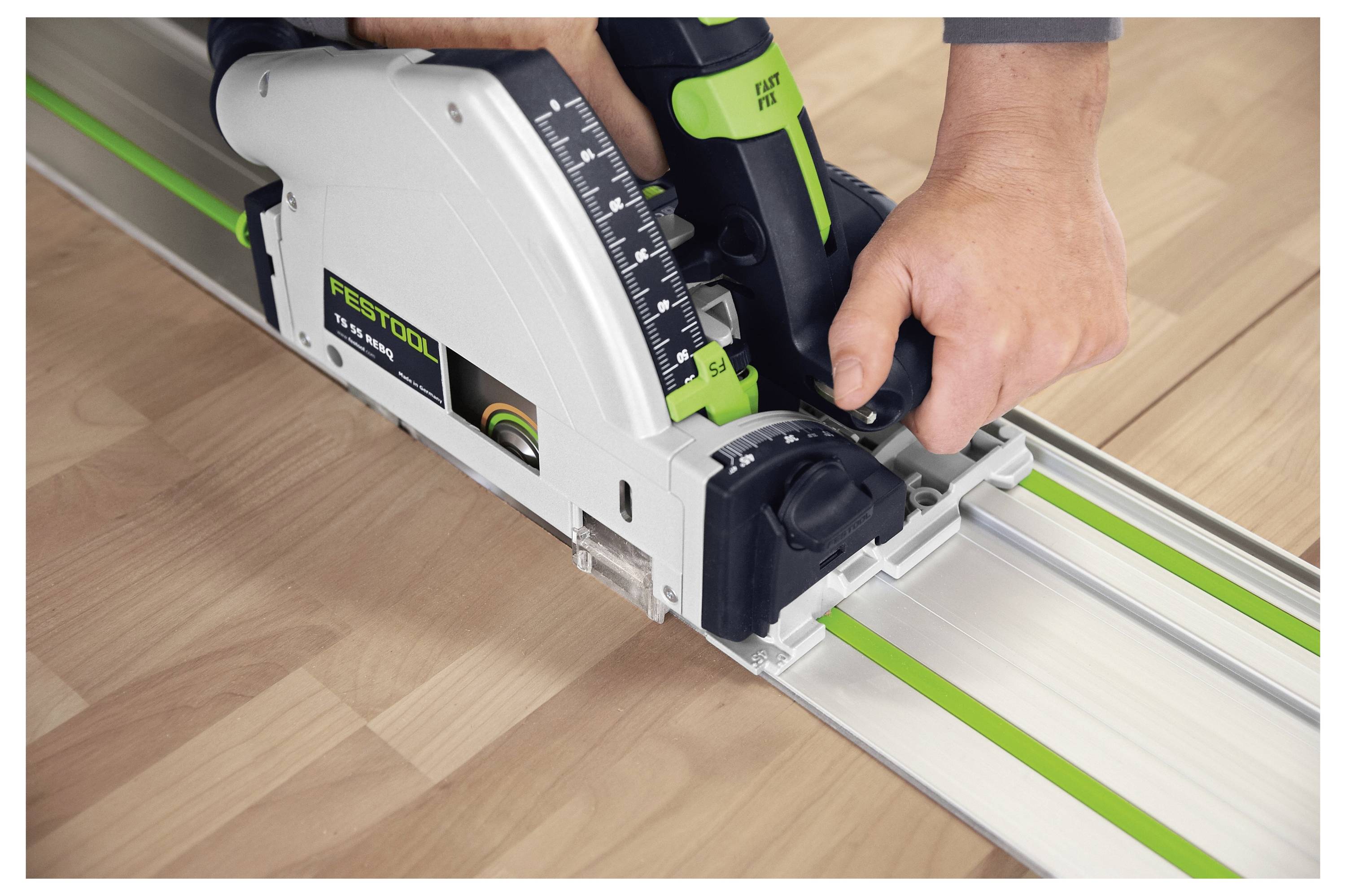 Eine Person benutzt eine Festool Tauchsäge, um eine Holzoberfläche entlang einer Metallführungsschiene für präzise und gerade Schnitte zu schneiden.