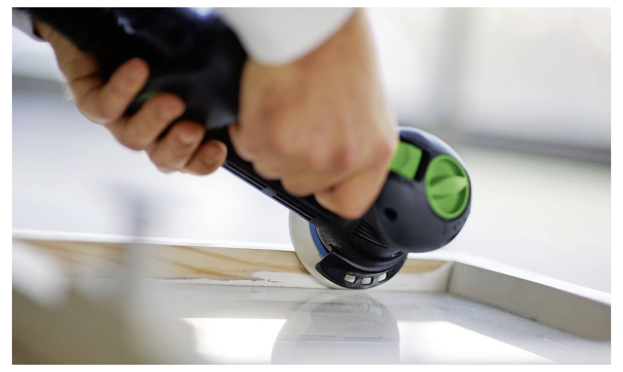 Eine kreisförmige Tischkreissäge, die Holz schneidet, mit sichtbarer 'Festool'-Markierung. Die Säge ist auf einem Tisch positioniert, bereit für präzises Schneiden.