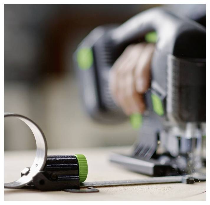 Eine Person nutzt eine Stichsäge, um Holz zu schneiden, wobei sie sich auf präzise Kontrolle konzentriert. Ein Messwerkzeug liegt in der Nähe, was auf sorgfältige Messung für Genauigkeit hindeutet.