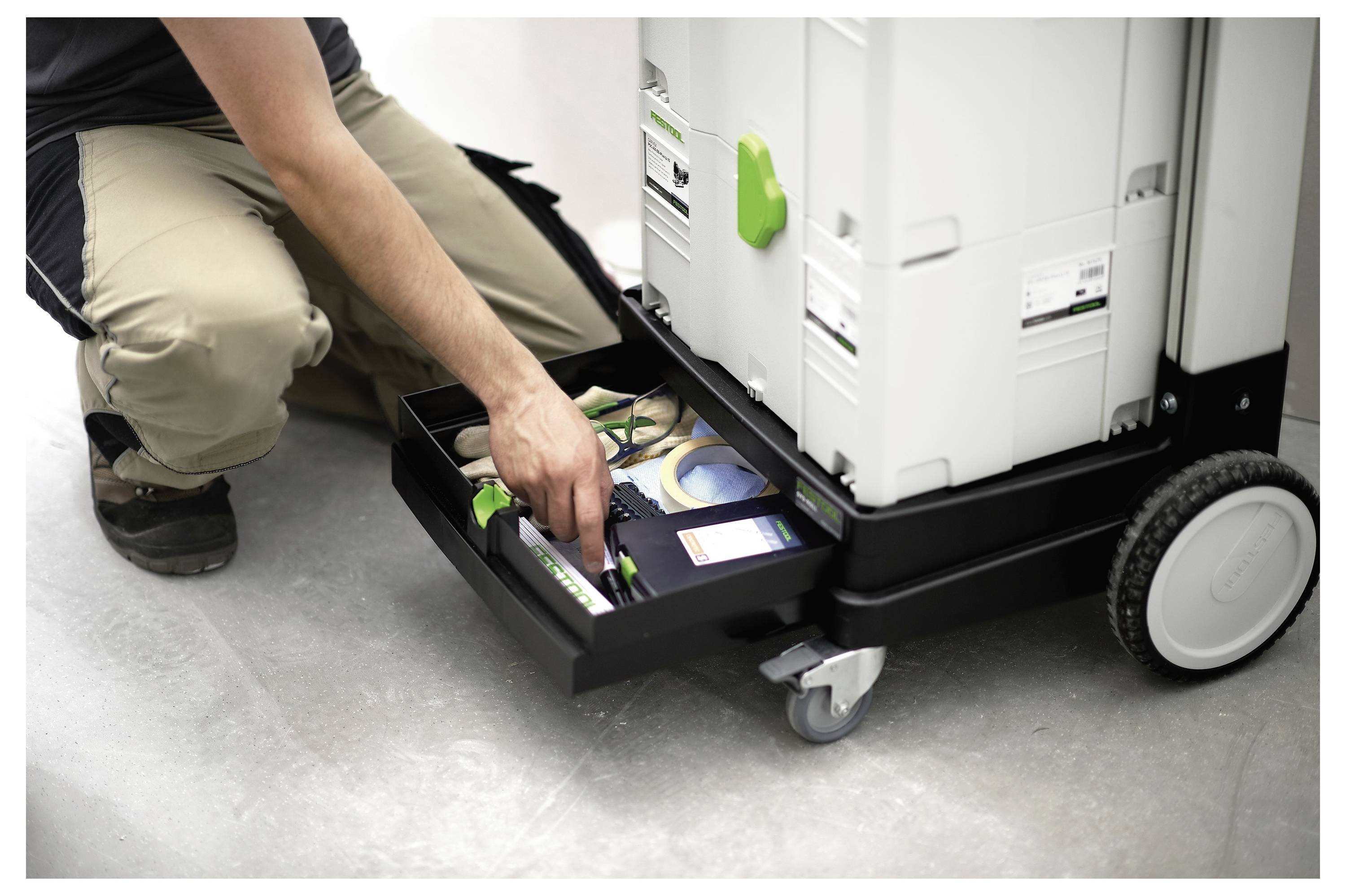 Eine Nahaufnahme eines tragbaren elektrischen Schleifers mit einem Staubabsaugschlauch, der das ergonomische Design und den Markennamen an der Seite hervorhebt.