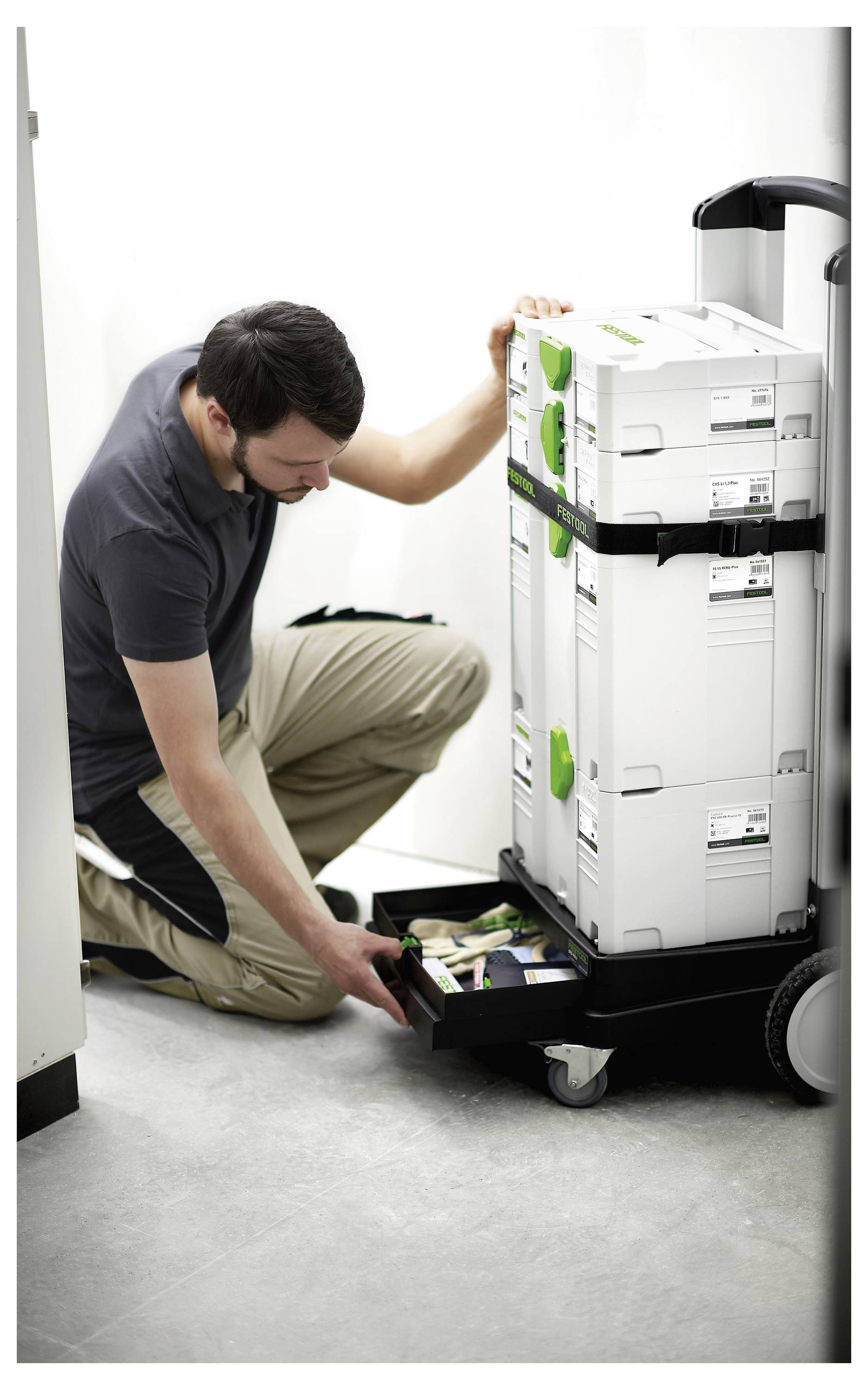 Eine schwarze Klemme sichert ein gelöchertes Holzbrett an einem Aluminium-Schienensystem und zeigt ein Tischkreissägen-Setup zum präzisen Schneiden.