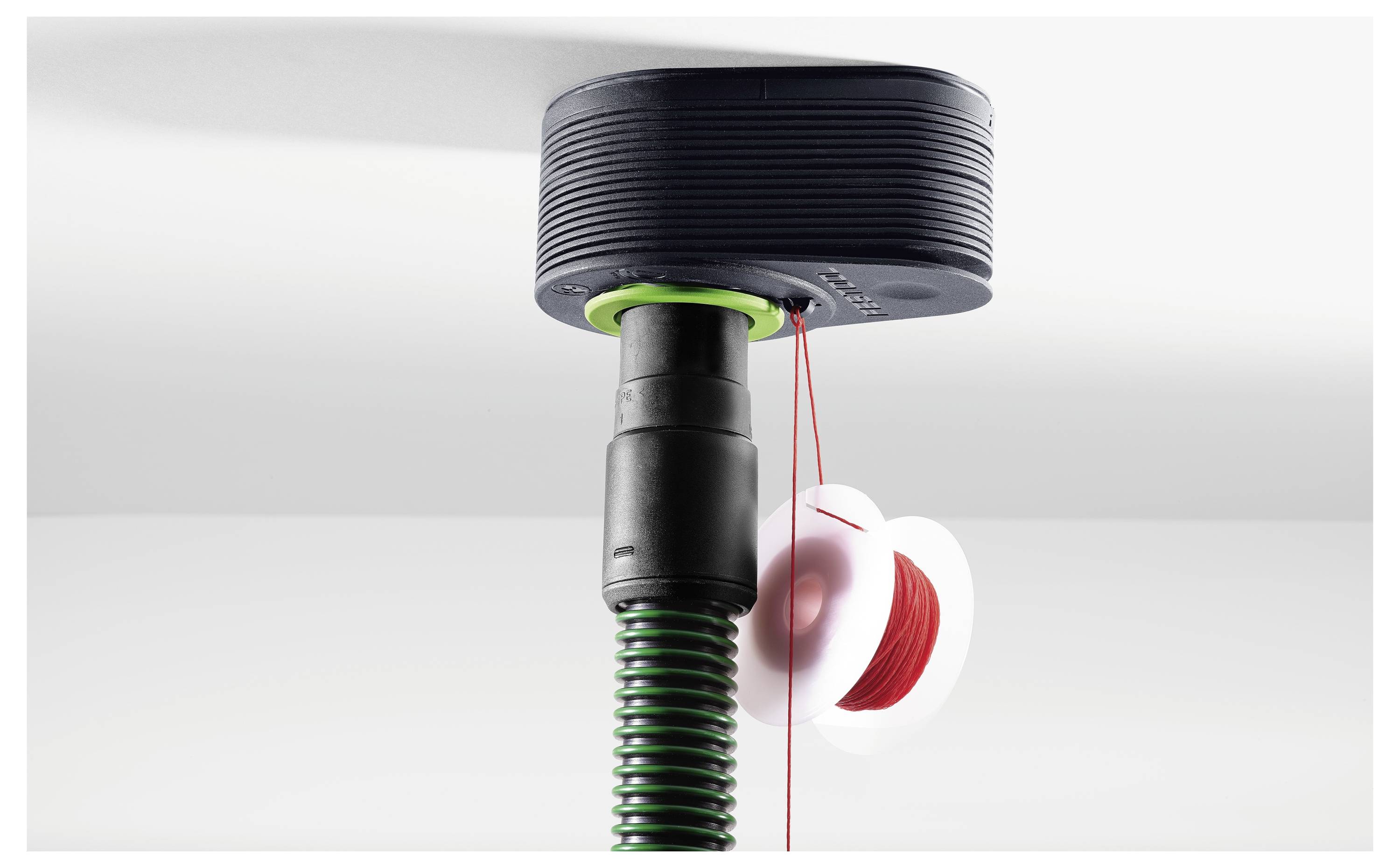 Ein Fadenkopf eines Unkrautvernichters mit eingespultem Fadenkopf, das rote Schneidlinie zeigt. Der Trimmer ist vor einem weißen Hintergrund positioniert.