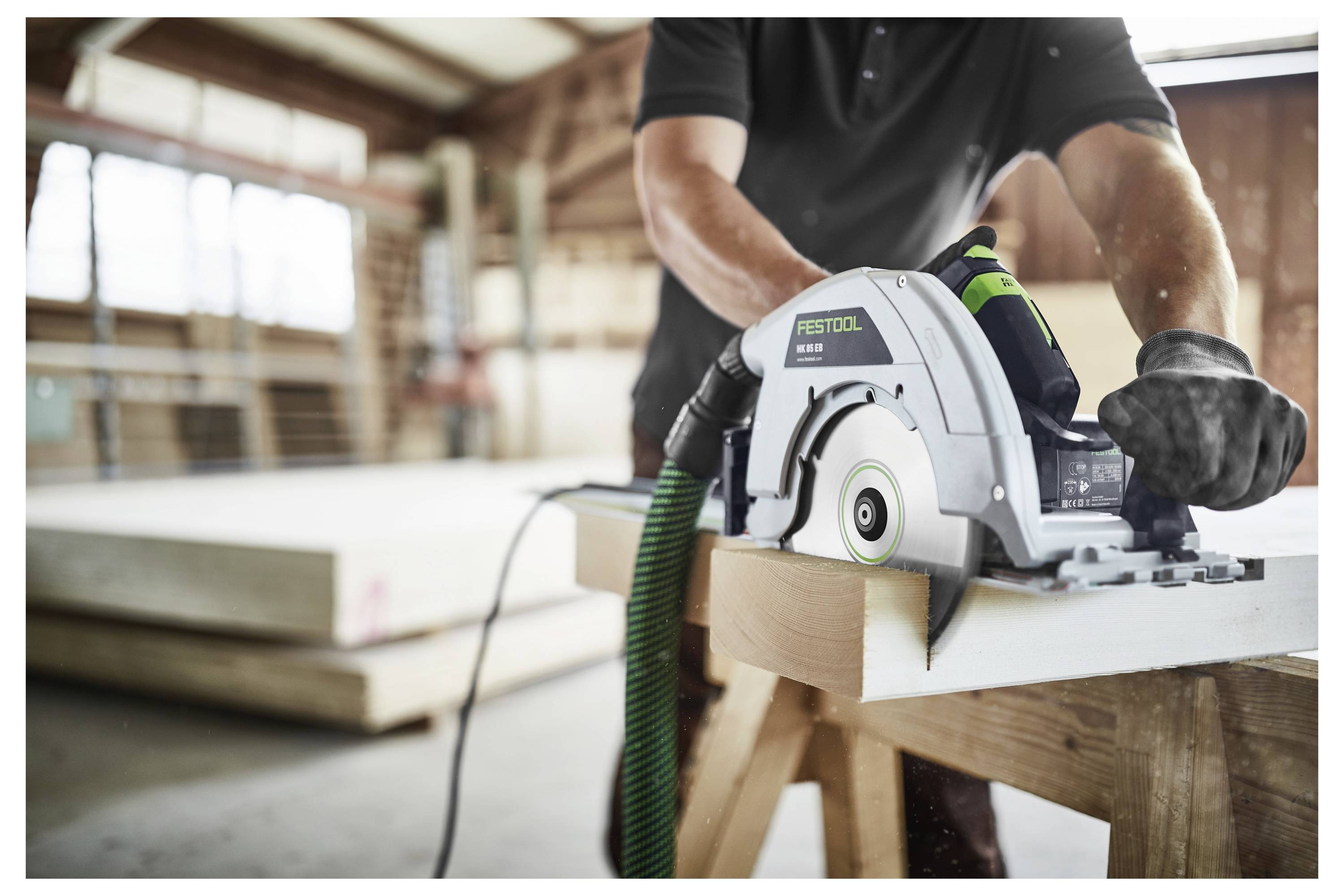 Eine Person nutzt eine Kreissäge, um Holz in einer Werkstatt zu schneiden und konzentriert sich dabei auf Genauigkeit und Sicherheit. Die Umgebung ist hell und ordentlich.