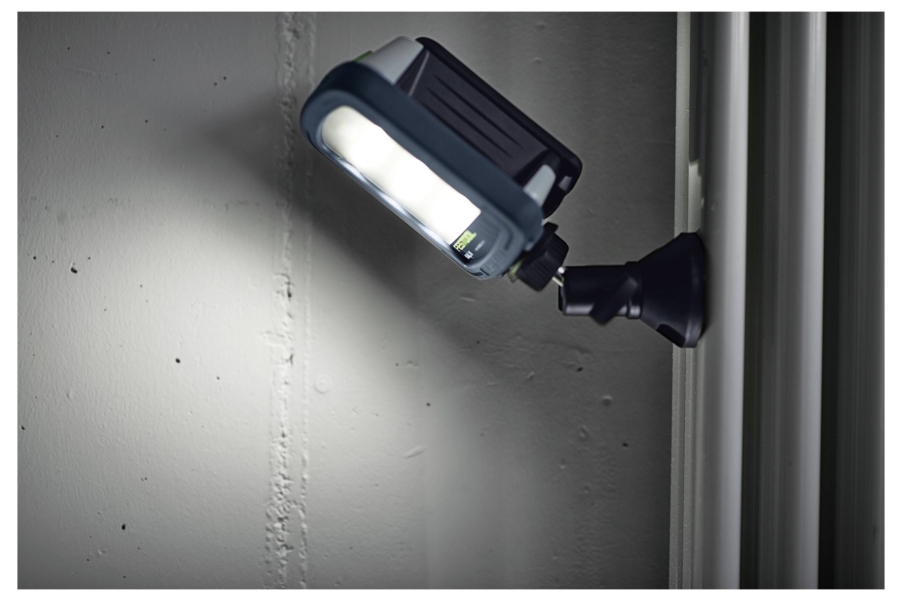 Eine an der Wand montierte LED-Leuchte, erleuchtet, die auf eine nahe gelegene Oberfläche in einer Innenraumsituation scheint und ihren verstellbaren Arm hervorhebt.