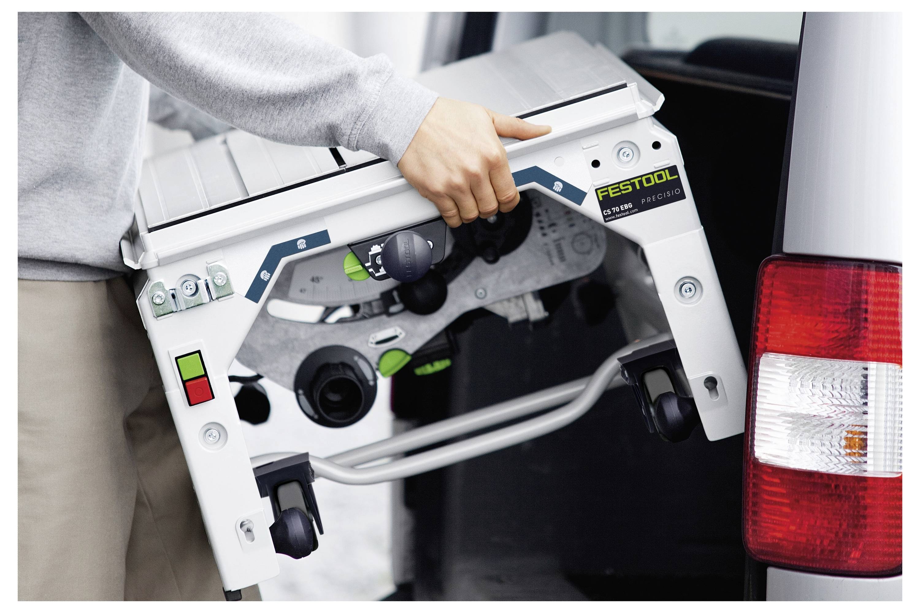 Eine Person lädt eine kompakte Festool-Tischkreissäge in ein Fahrzeug und unterstreicht dabei die Portabilität und den einfachen Transport des Werkzeugs.