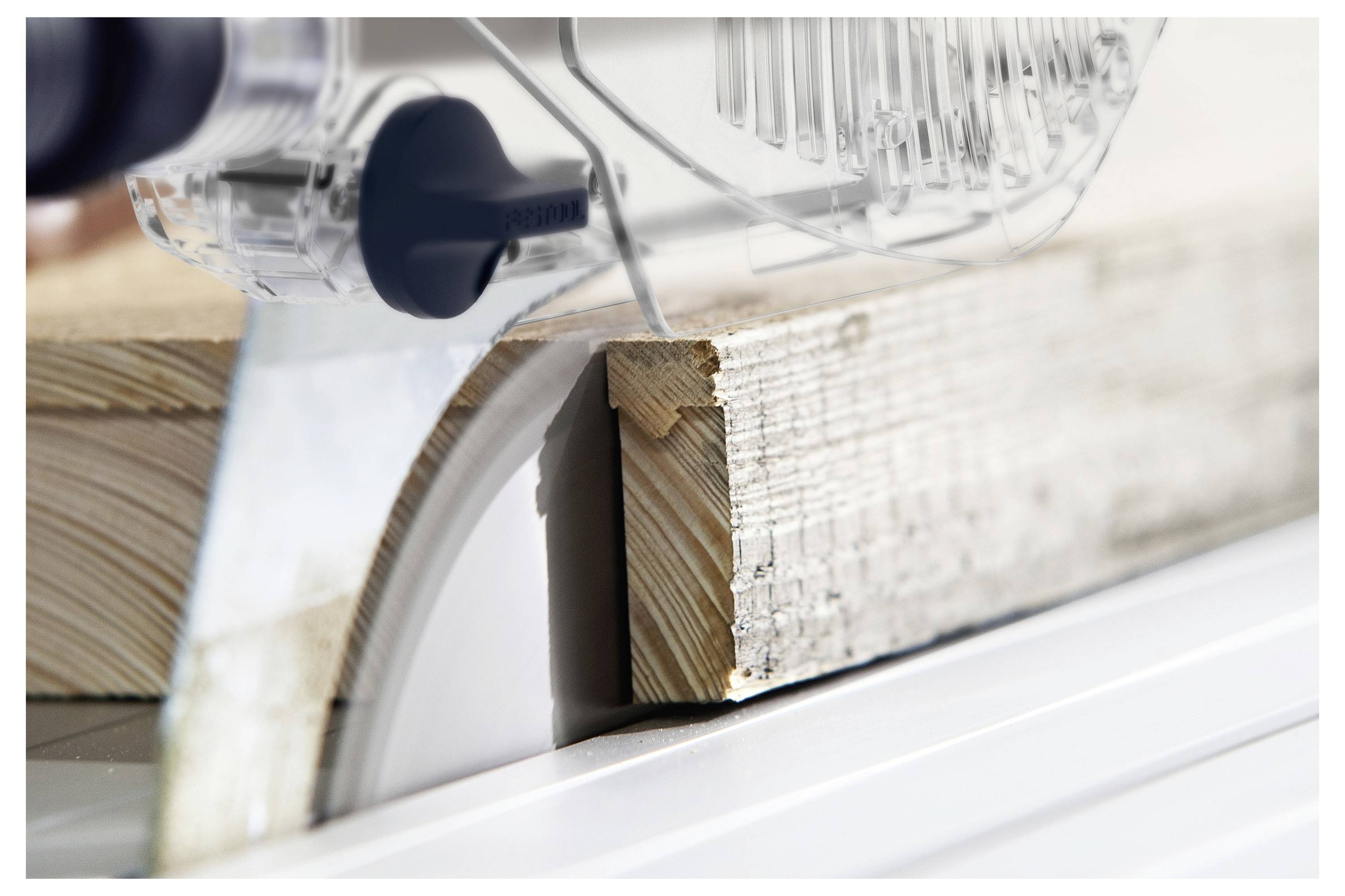 Ein Holzbrett, das von einer Tischkreissäge geschnitten wird.