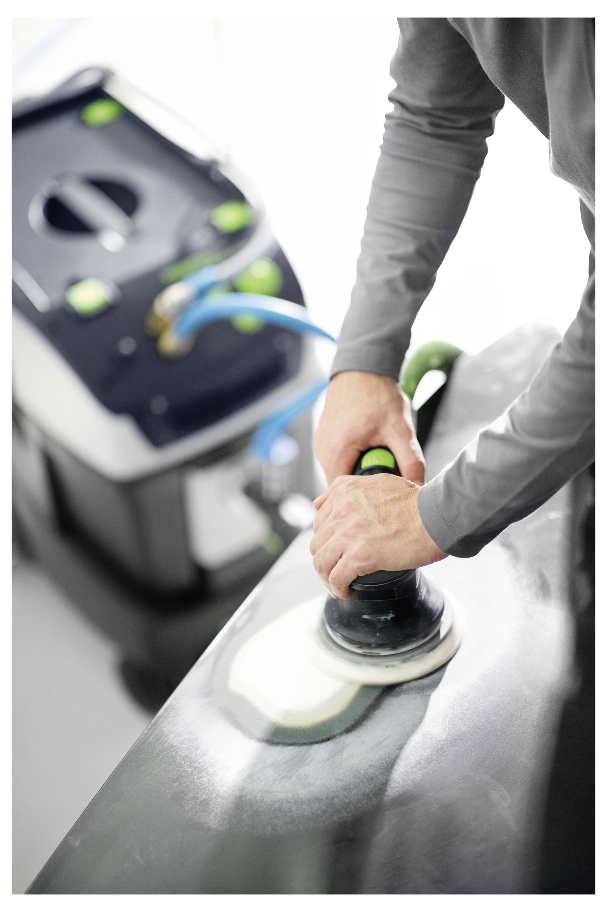 „Person, die einen Elektroschleiffer auf der Autoberfläche verwendet, mit einer Absaugmaschine im Hintergrund, die durch einen blauen Schlauch verbunden ist.