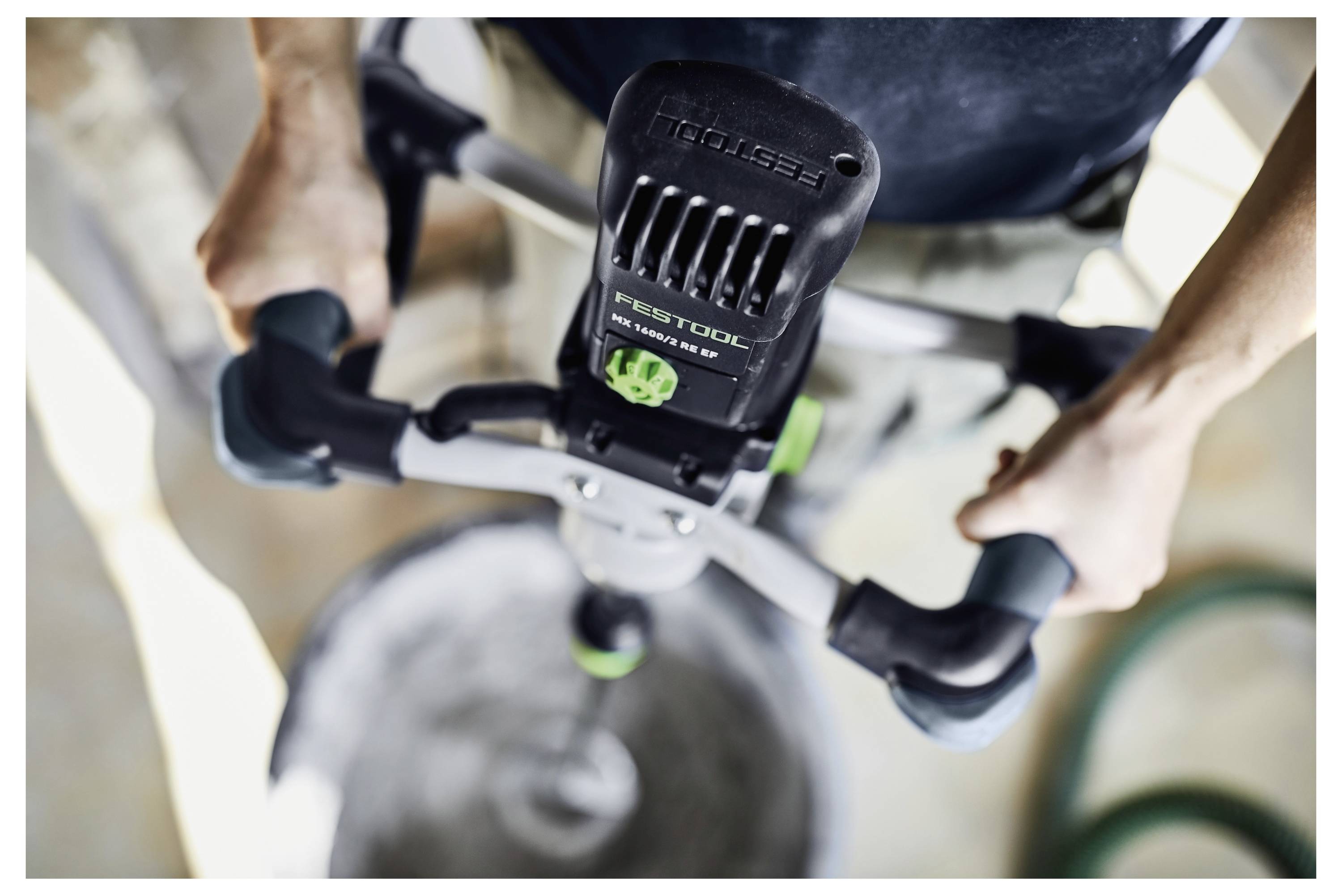 Eine Person verwendet einen Mischer, um Material in einem großen Behälter zu mischen, wobei der Fokus auf Bau- oder Heimwerkerarbeiten liegt.