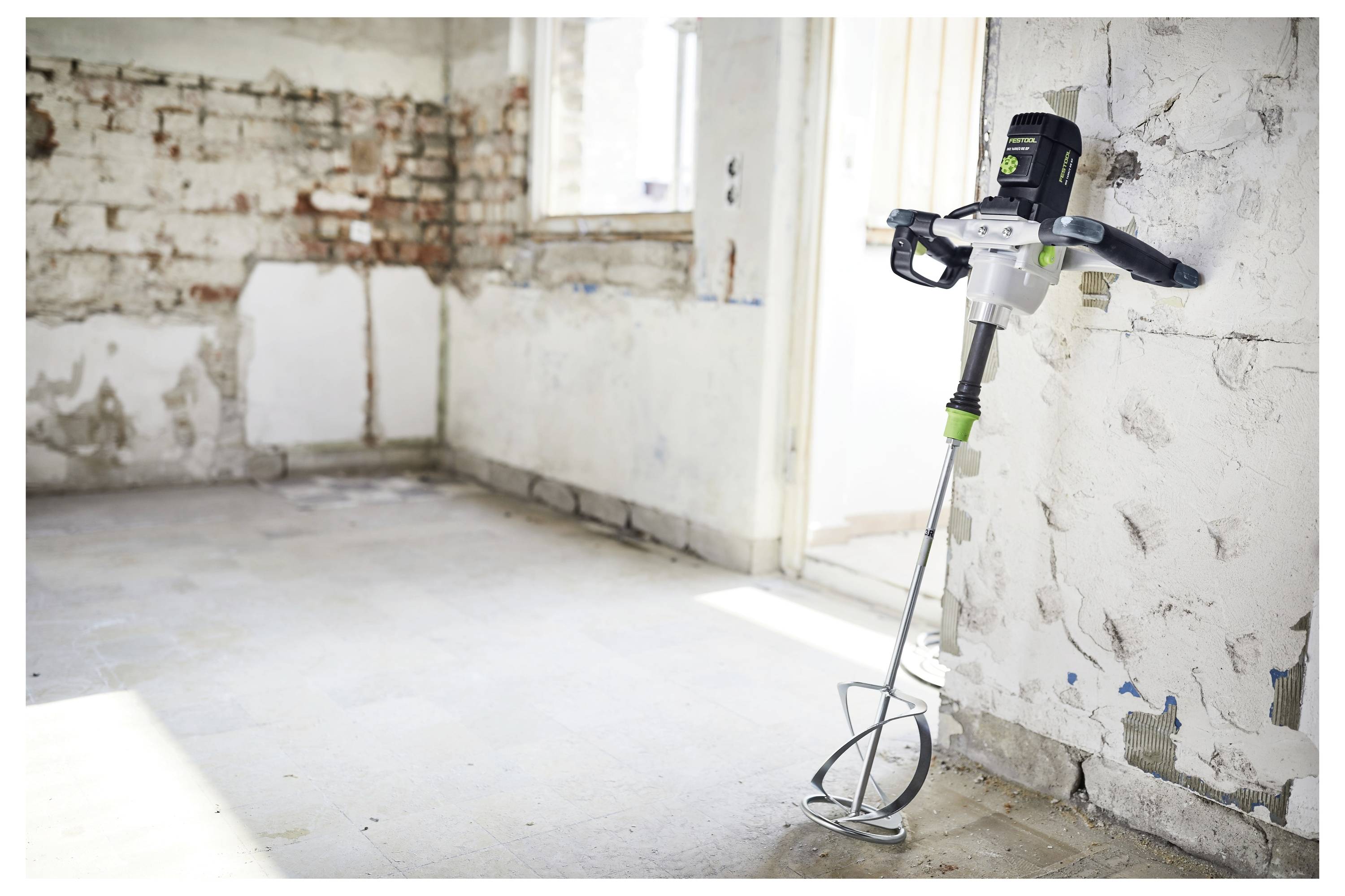 Eine Person mit Schutzbrille und Gehörschutz verwendet einen Bohrer, um eine Deckenleuchte zu installieren oder zu reparieren.