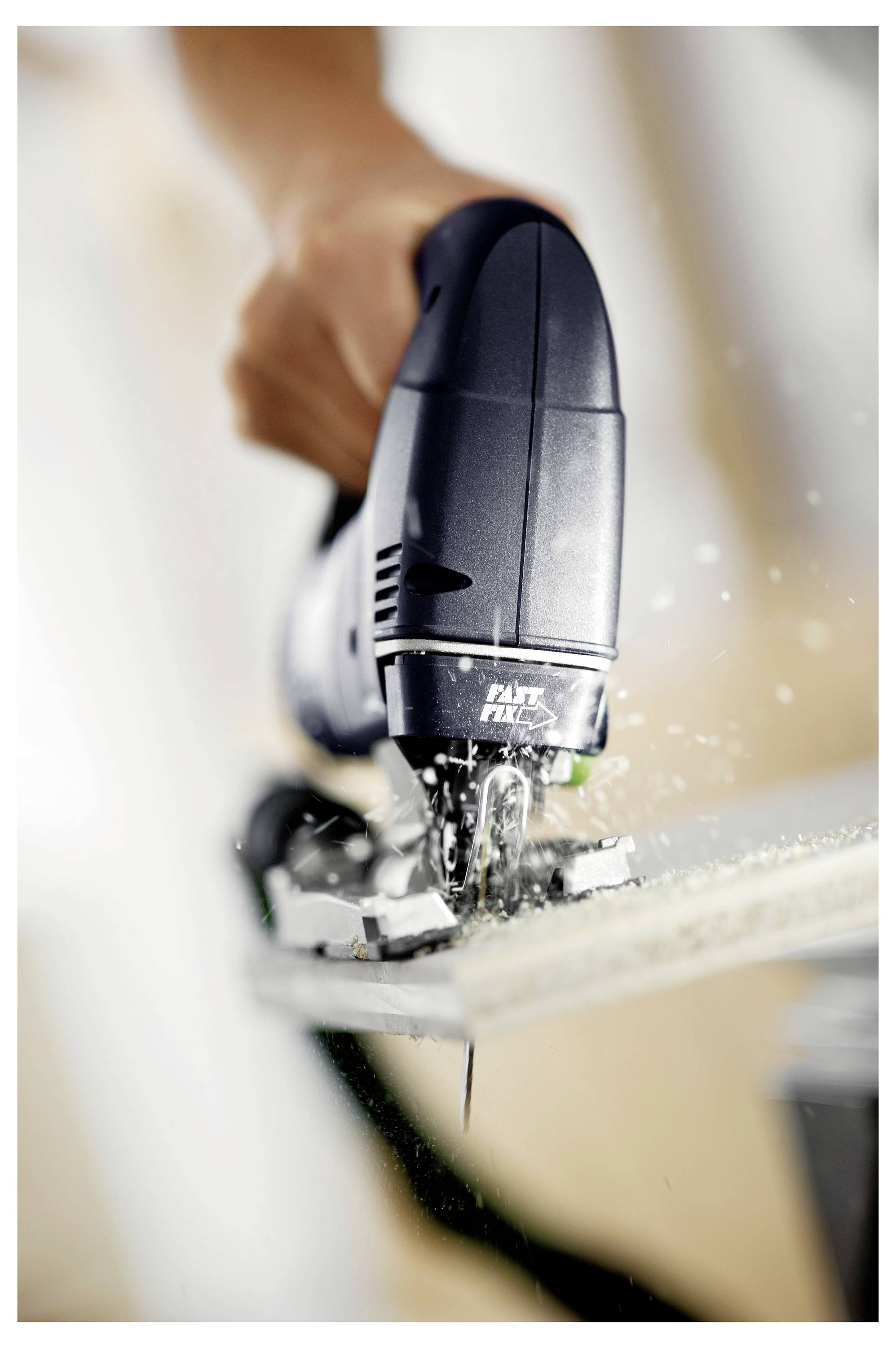 Eine Hand bedient eine Stichsäge, die mit Präzision durch Holz schneidet und Holzspäne aufwirbelt, während sie Holzbearbeitungswerkzeuge in Aktion zeigt.