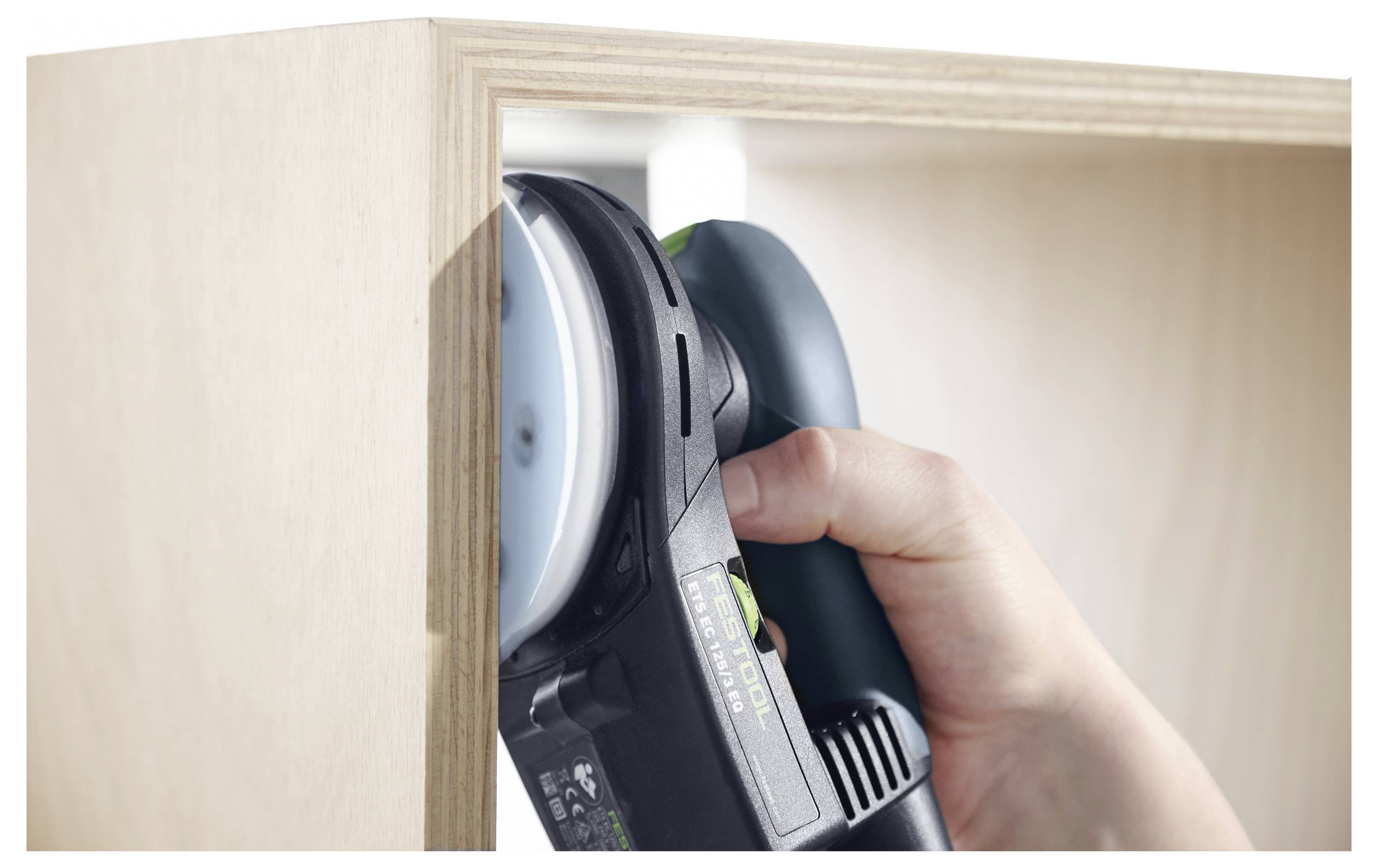 Eine Person verwendet ein Festool-Schleifwerkzeug auf einer roten Oberfläche und demonstriert dabei einen Glättungsprozess.