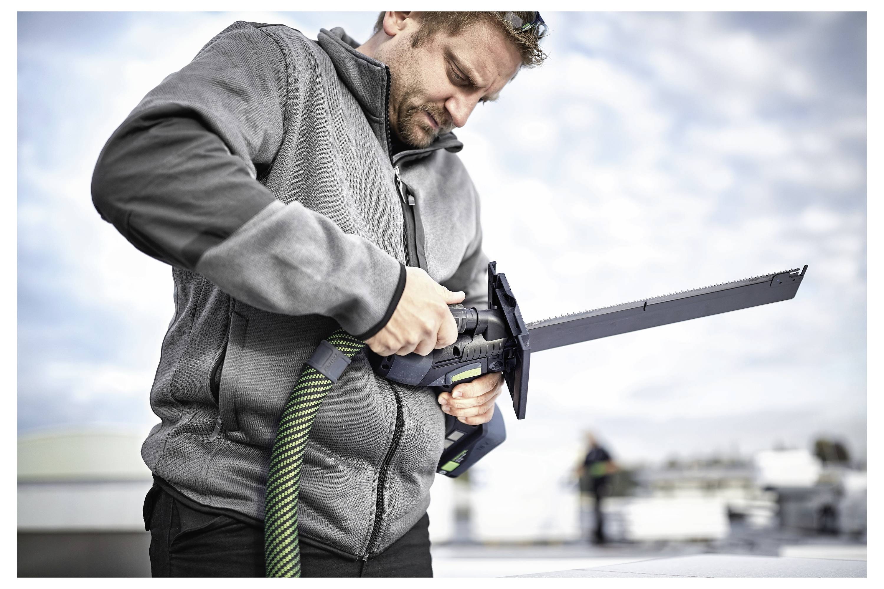 Eine Person benutzt einen tragbaren Elektroschleiffer auf einer weißen Holzoberfläche und konzentriert sich darauf, das Material zu glätten oder zu polieren.