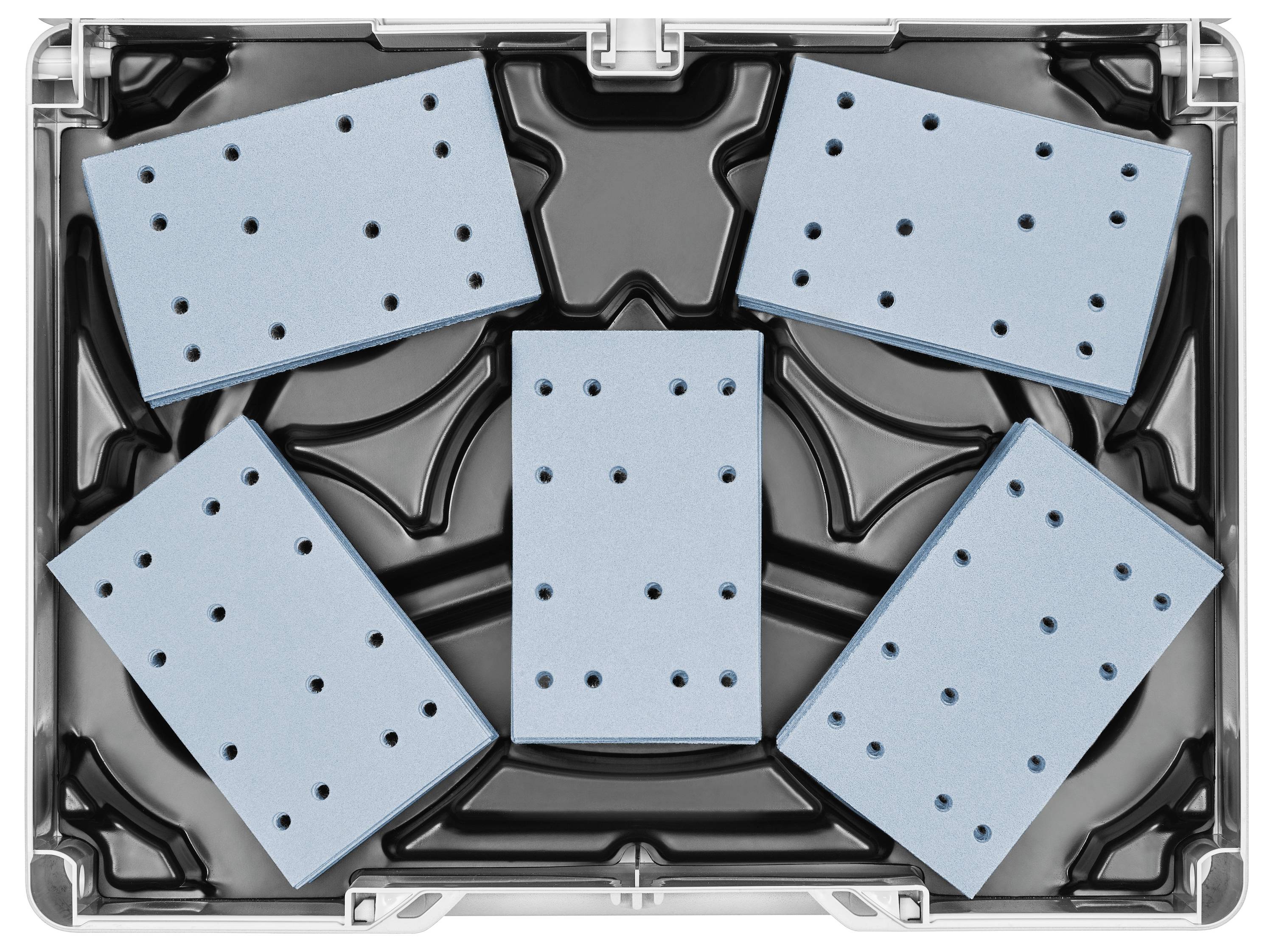 Eine Person benutzt einen blau-grünen kabellosen Bohrer auf einer Stehleiter und hält einen Bohraufsatz. Der Bohrer trägt die Marke „Festool