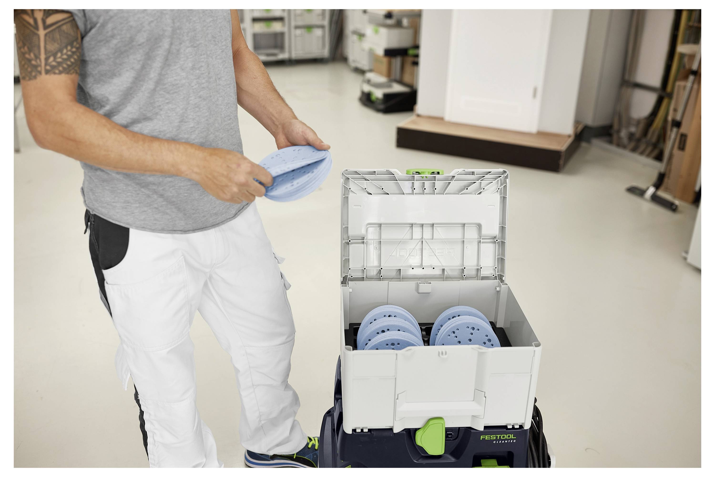 Nahaufnahme des Festool-Staubabsaugschlauches und der an ein Werkzeug angeschlossenen Befestigung, die die Markierung und das Verbindungsdetail hervorhebt.