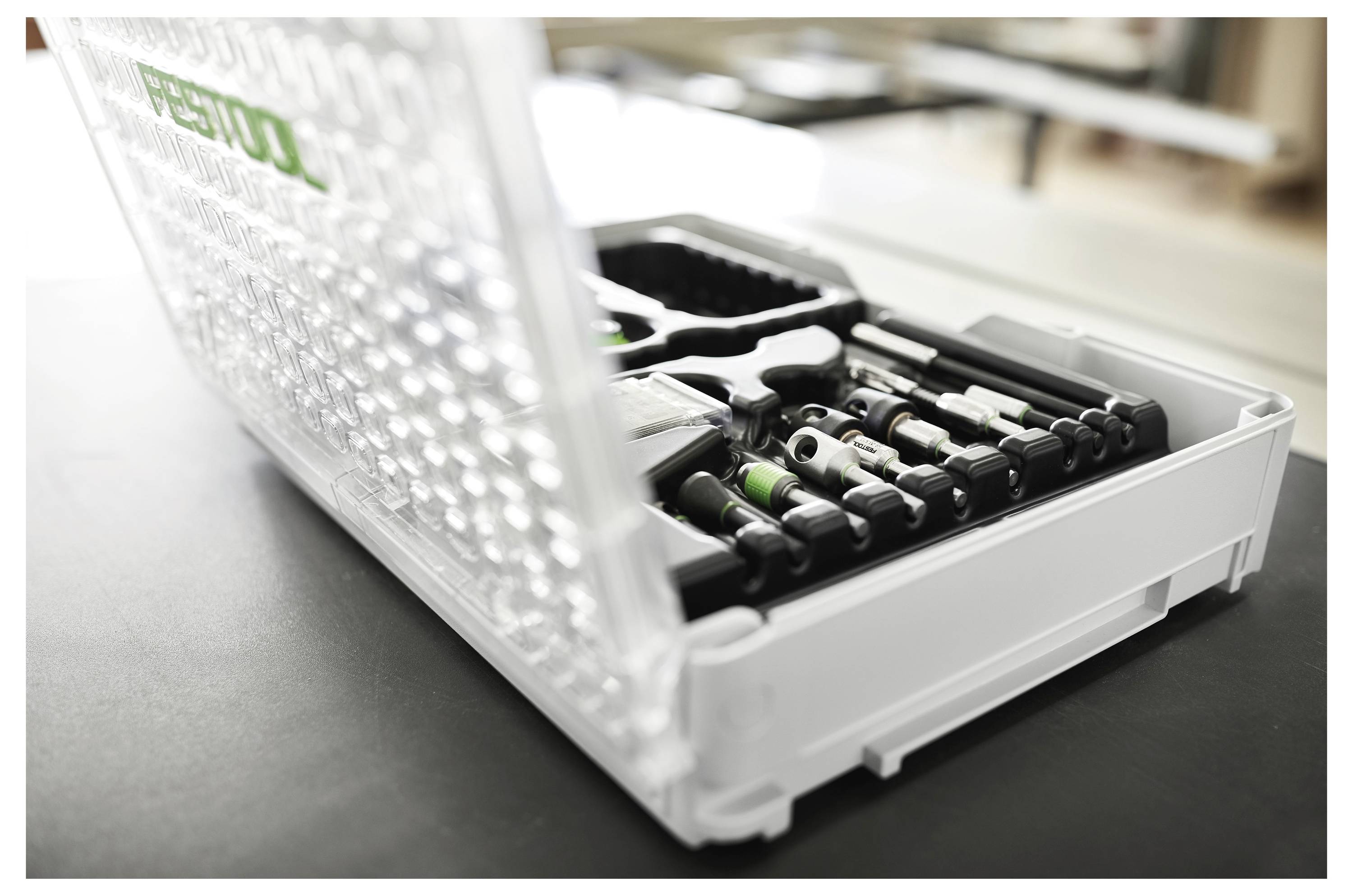 Eine offene, transparente Werkzeugbox mit ordentlich angeordneten Werkzeugen, einschließlich Schraubendreher, Schraubenschlüssel und einem Hammer.