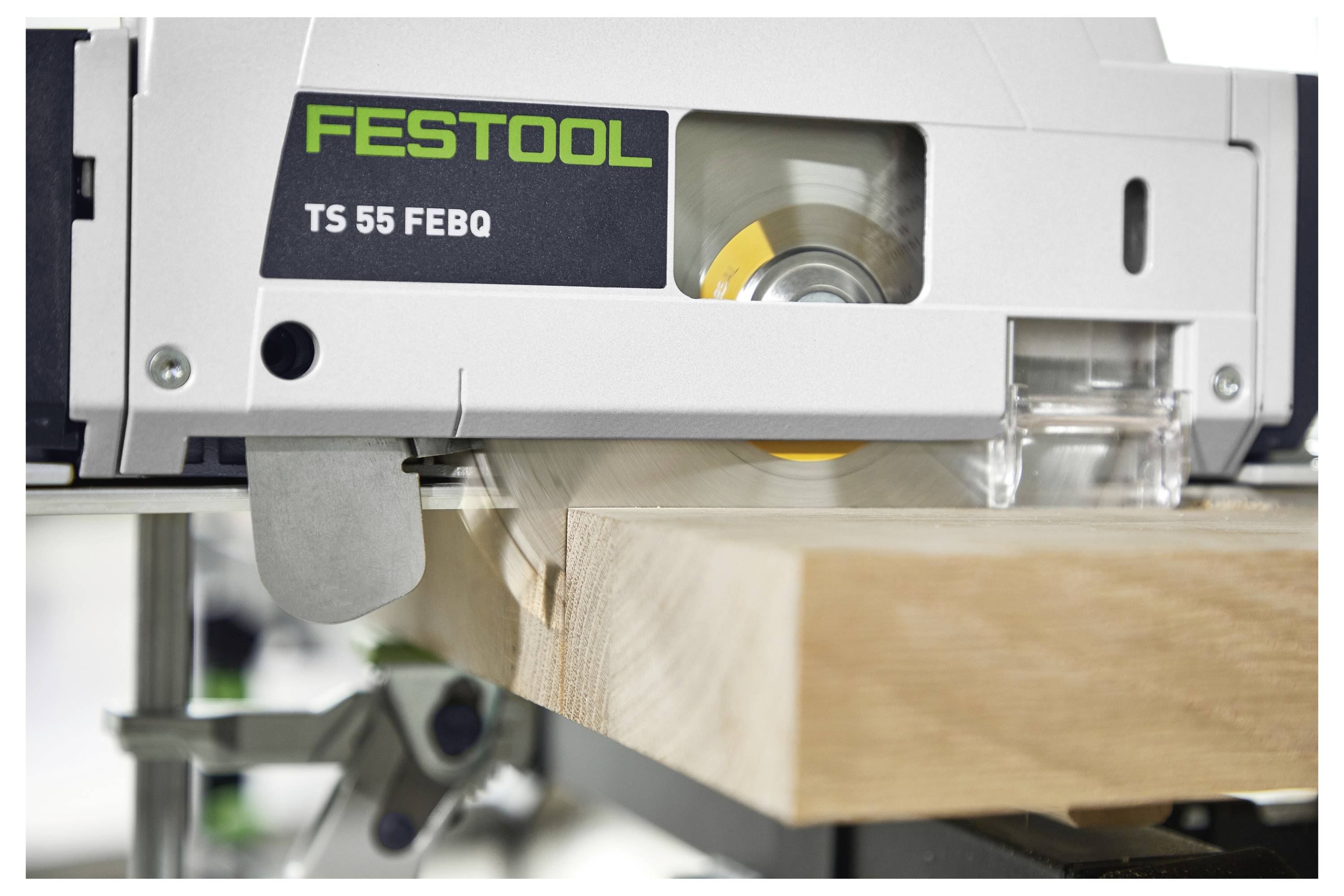 Eine Nahaufnahme einer Festool TS 55 FEBQ Kreissäge, die durch ein Holzbrett schneidet, mit dem Sägeblatt in Bewegung und sichtbarem Markenlogo.