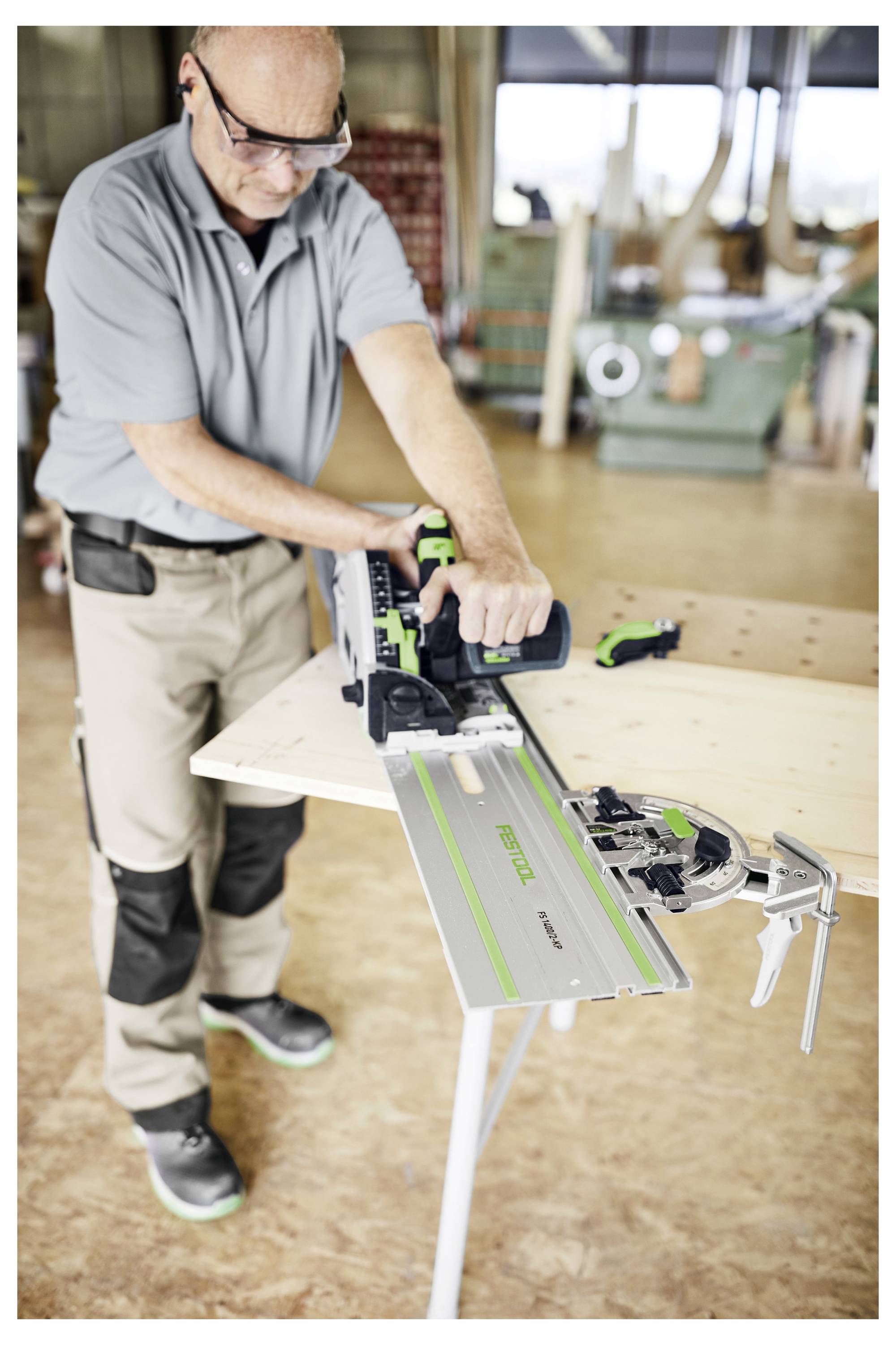 Eine Person nutzt ein Elektrowerkzeug, um Holz auf einer Werkbank in einer Werkstatt zu schneiden.