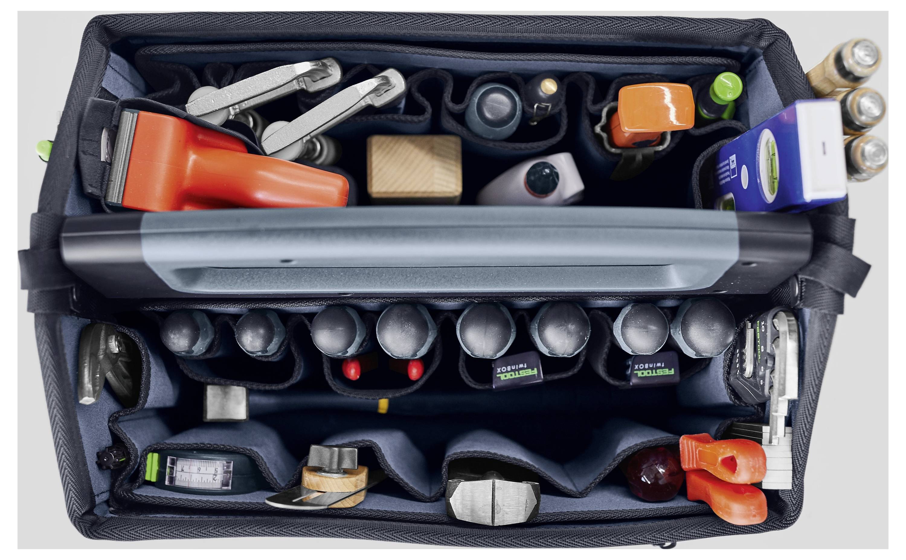 Eine Draufsicht auf eine organisierte Werkzeugtasche, die verschiedene Werkzeuge und Gegenstände enthält, darunter Schraubenschlüssel, einen Hammer und abgefüllte Materialien.