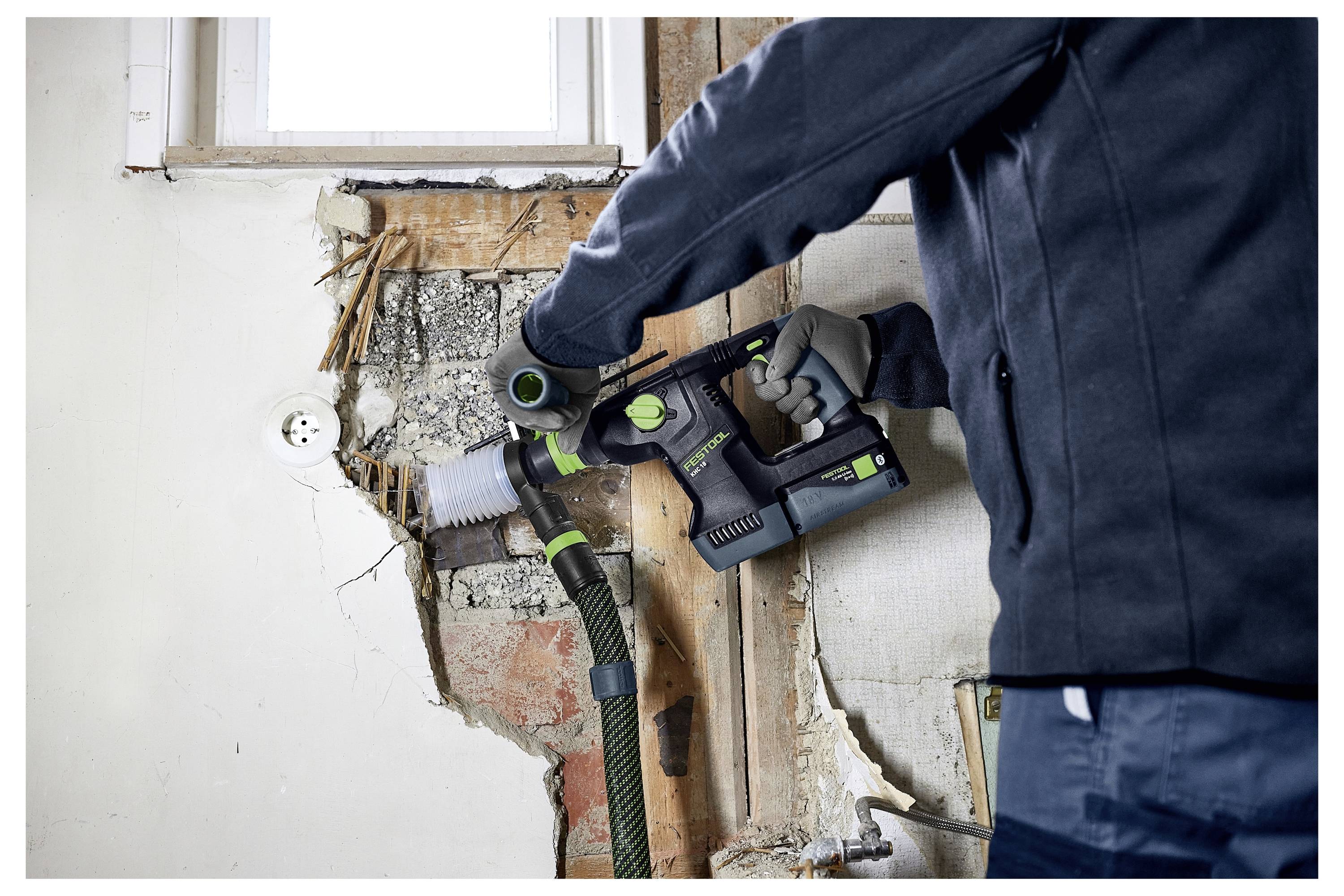 Eine Hand schleift ein Holzgeländer mit einem Elektroschleiffer ab und glättet die Holzoberfläche, wobei der Auffrischungsprozess hervorgehoben wird.