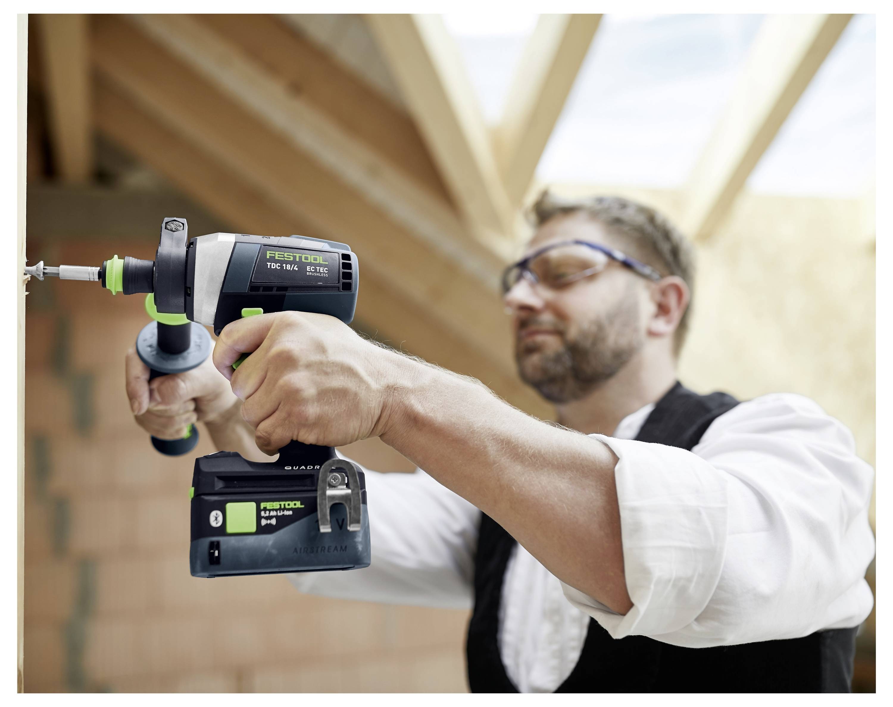 Eine Person verwendet einen Festool-Schleifera, um eine Holzoberfläche zu glätten, wobei das ergonomische Design des Werkzeugs und die Staubabsaugungsfunktion hervorgehoben werden.