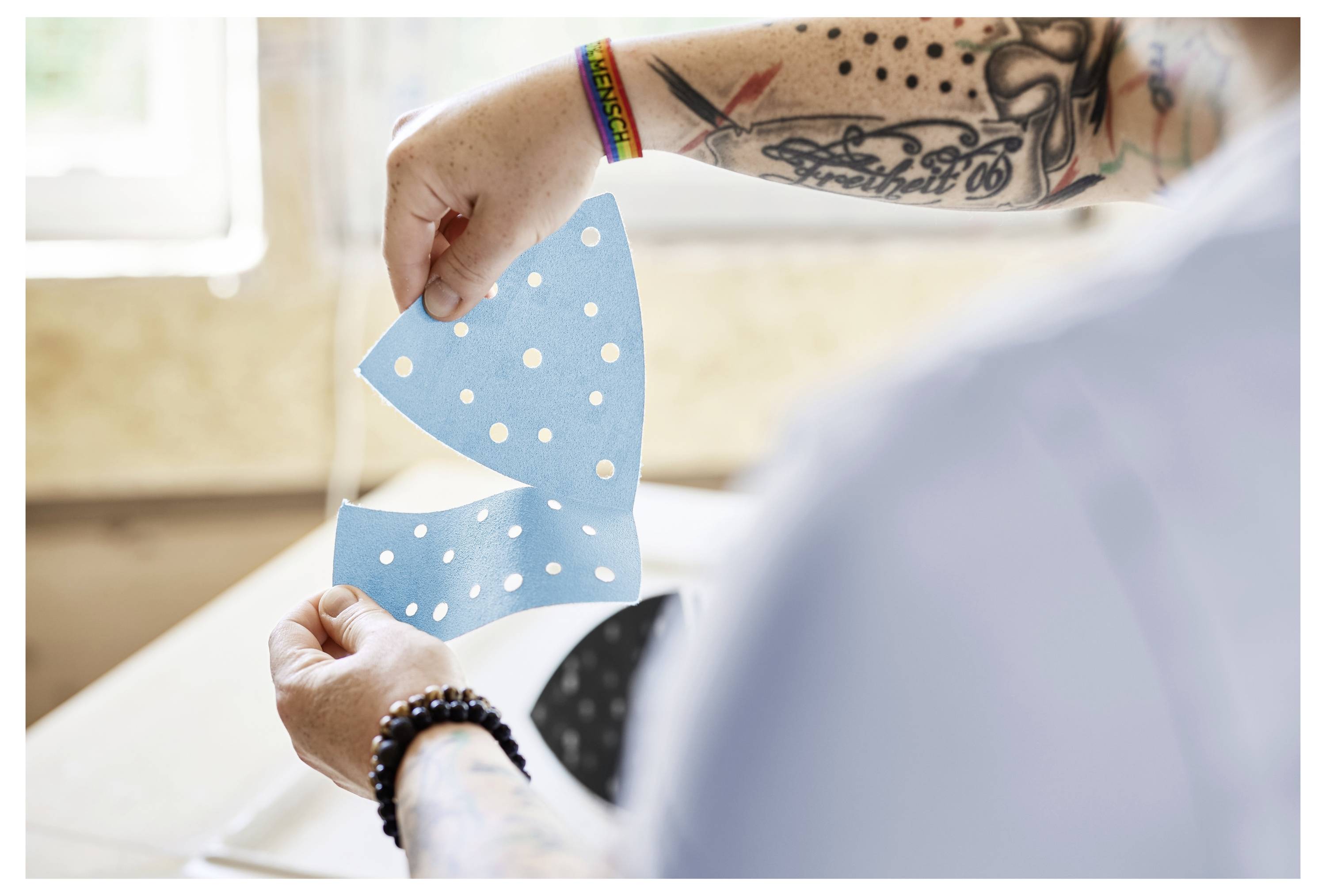 Eine Person bedient eine Elektrosäge und schneidet Holzbretter mit Präzision. Der Fokus liegt auf dem Werkzeug und den Händen, die den Schnitt führen.