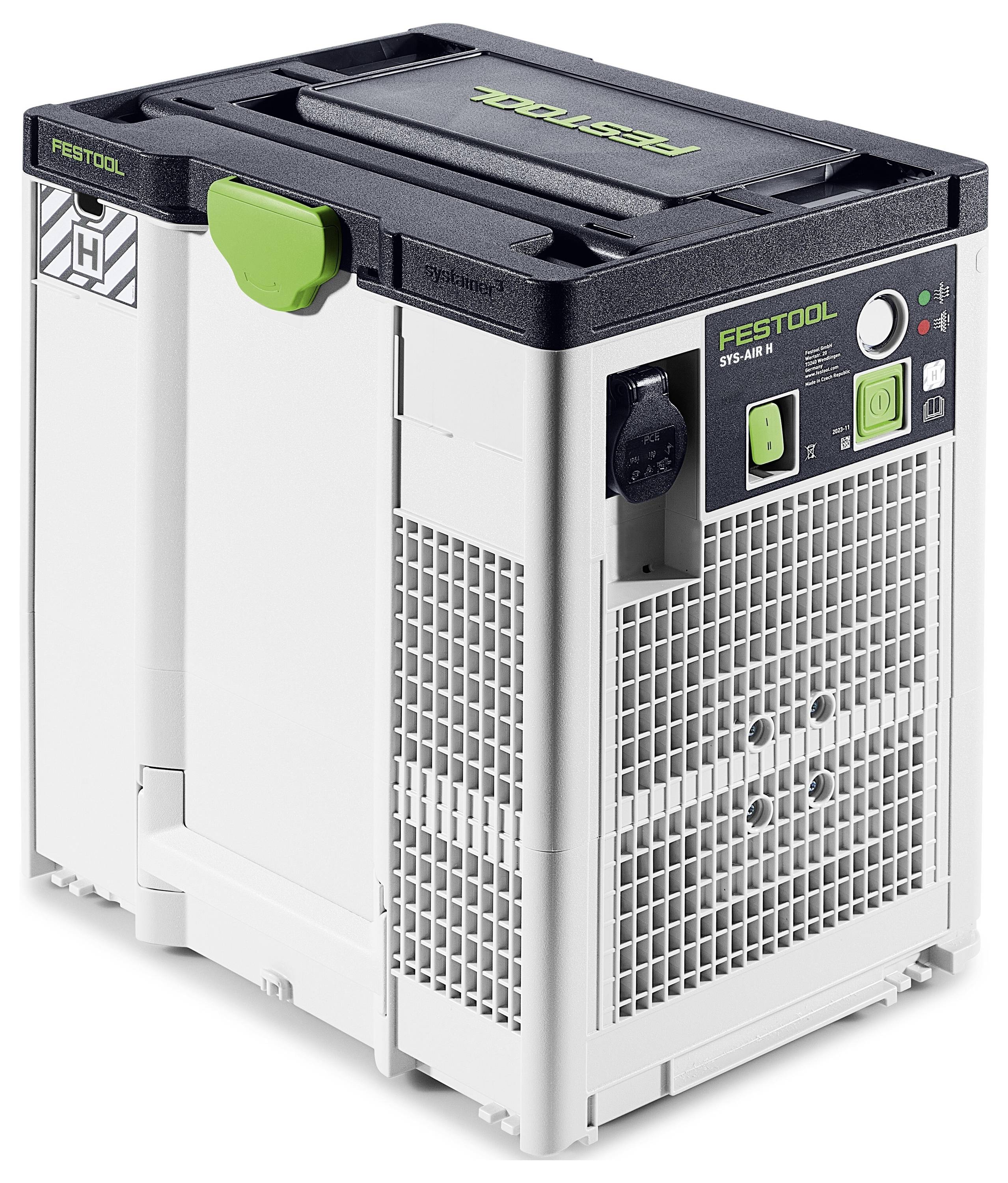 Vier Batterieladegeräte auf einem Stapel langer Holzbretter auf einem Werkstattboden, mit einem Stromkabel, das an einem Ladegerät angeschlossen ist.