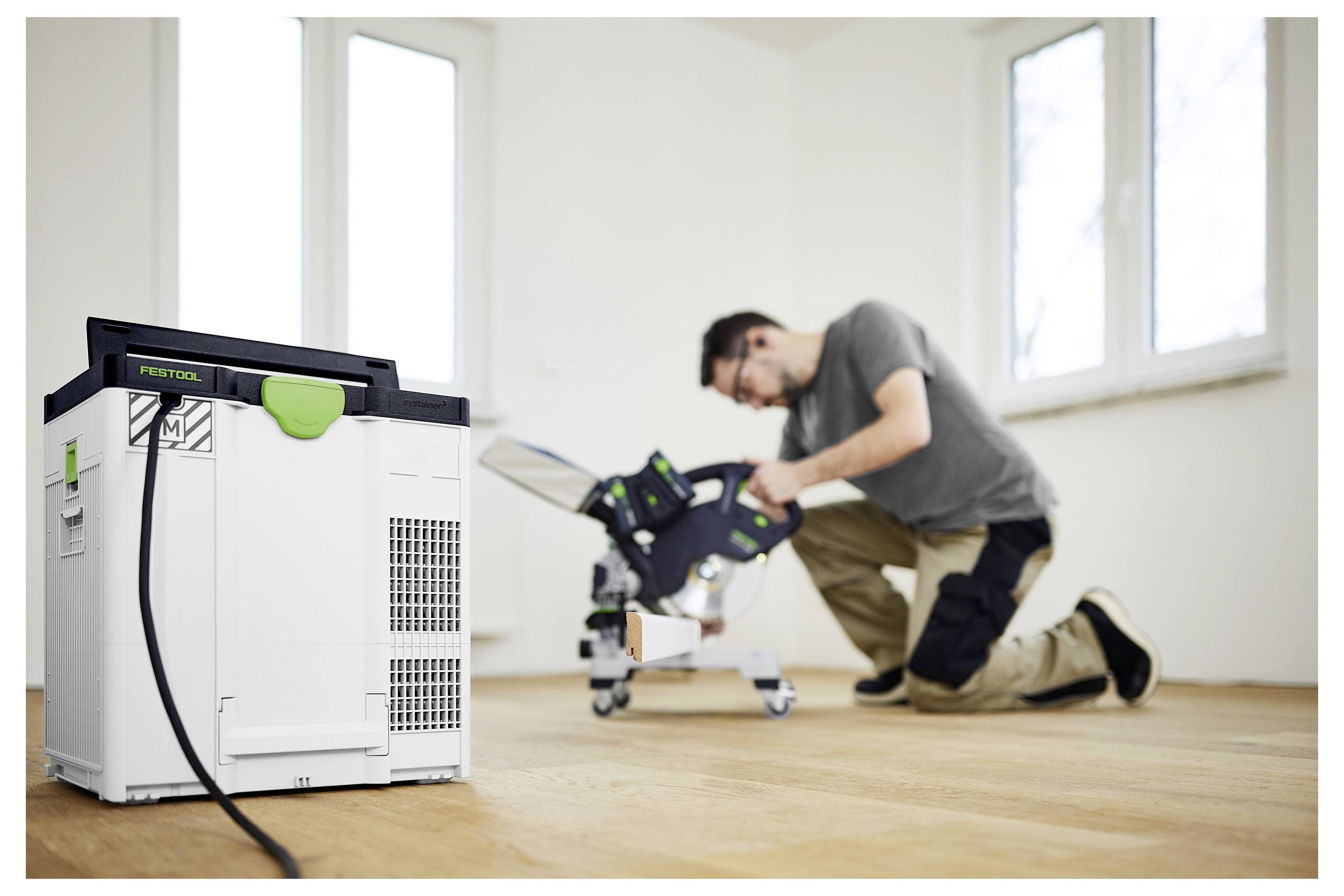 Eine Person trägt einen tragbaren Staubsauger eine Treppe hinunter und zeigt sein kompaktes und leichtes Design, das für einfachen Transport geeignet ist.