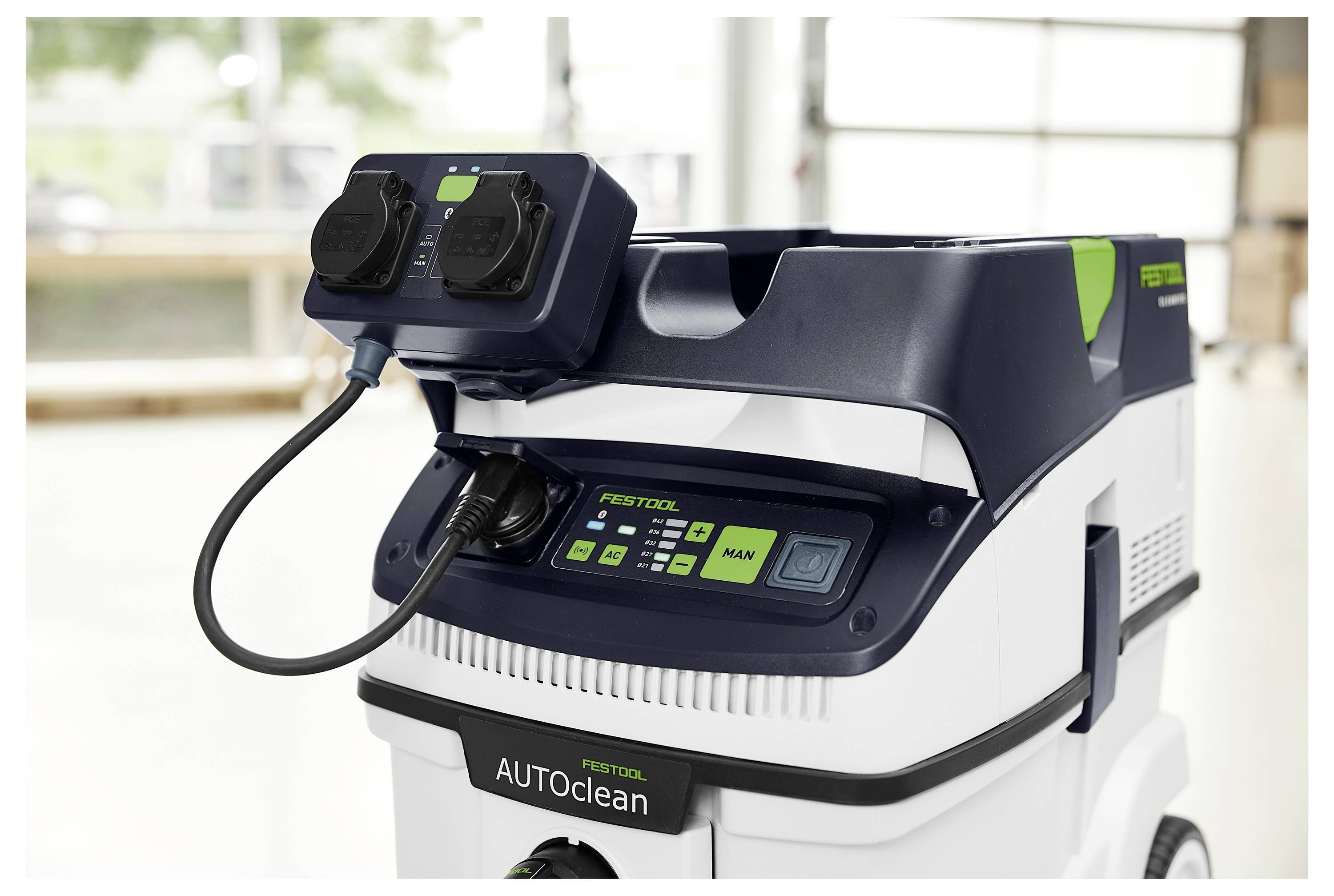 Eine Person benutzt einen kabellosen Bohrer, um eine Schraube in eine Oberfläche in einer Baustelle zu treiben. Die Person trägt eine Schutzbrille.