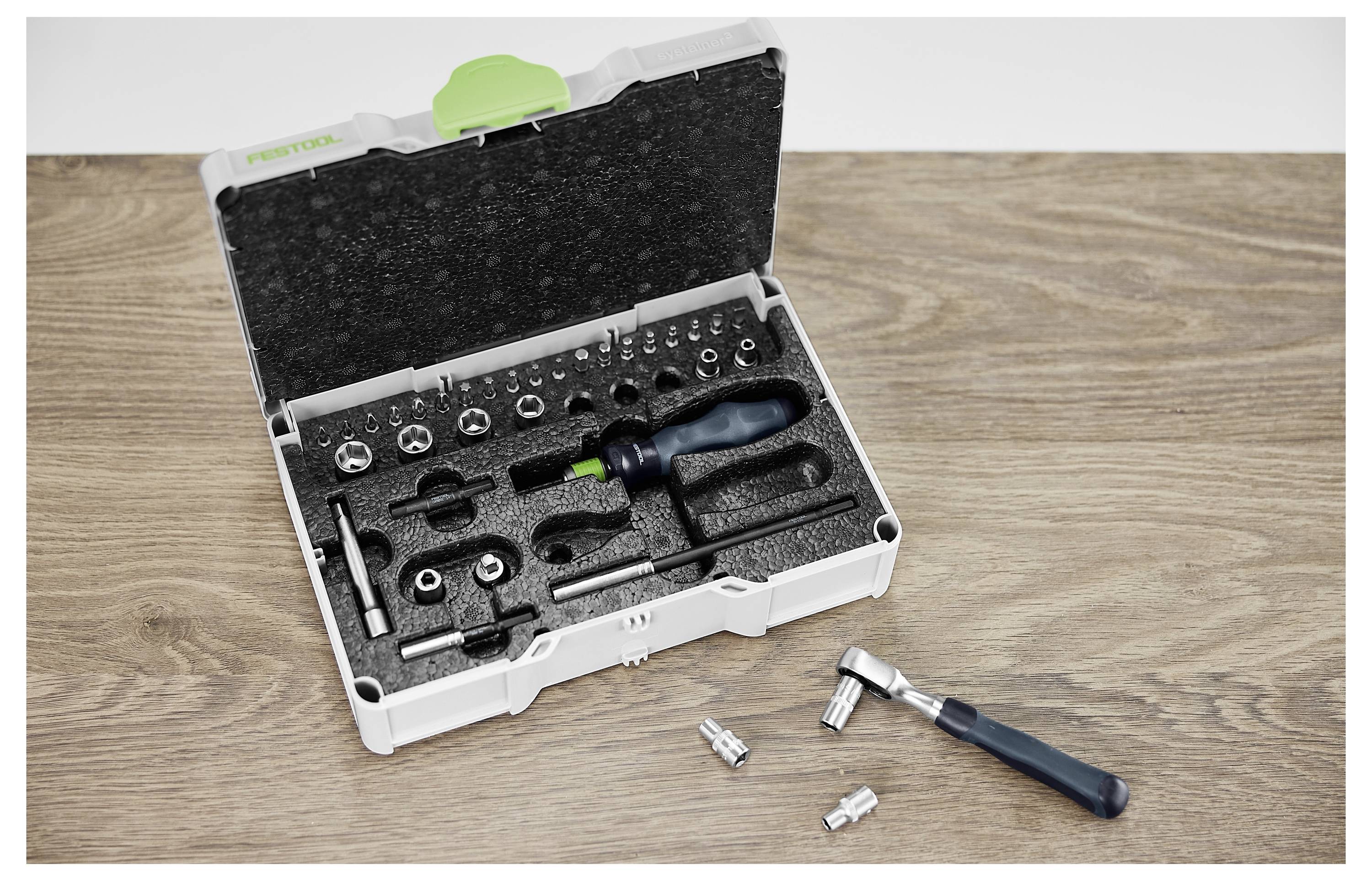 Eine Person benutzt ein Elektrowerkzeug, um ein Holzbrett zu schneiden, wobei ein flexibler Schlauch an dem Werkzeug angebracht ist. Innenbereich einer Werkstatt.