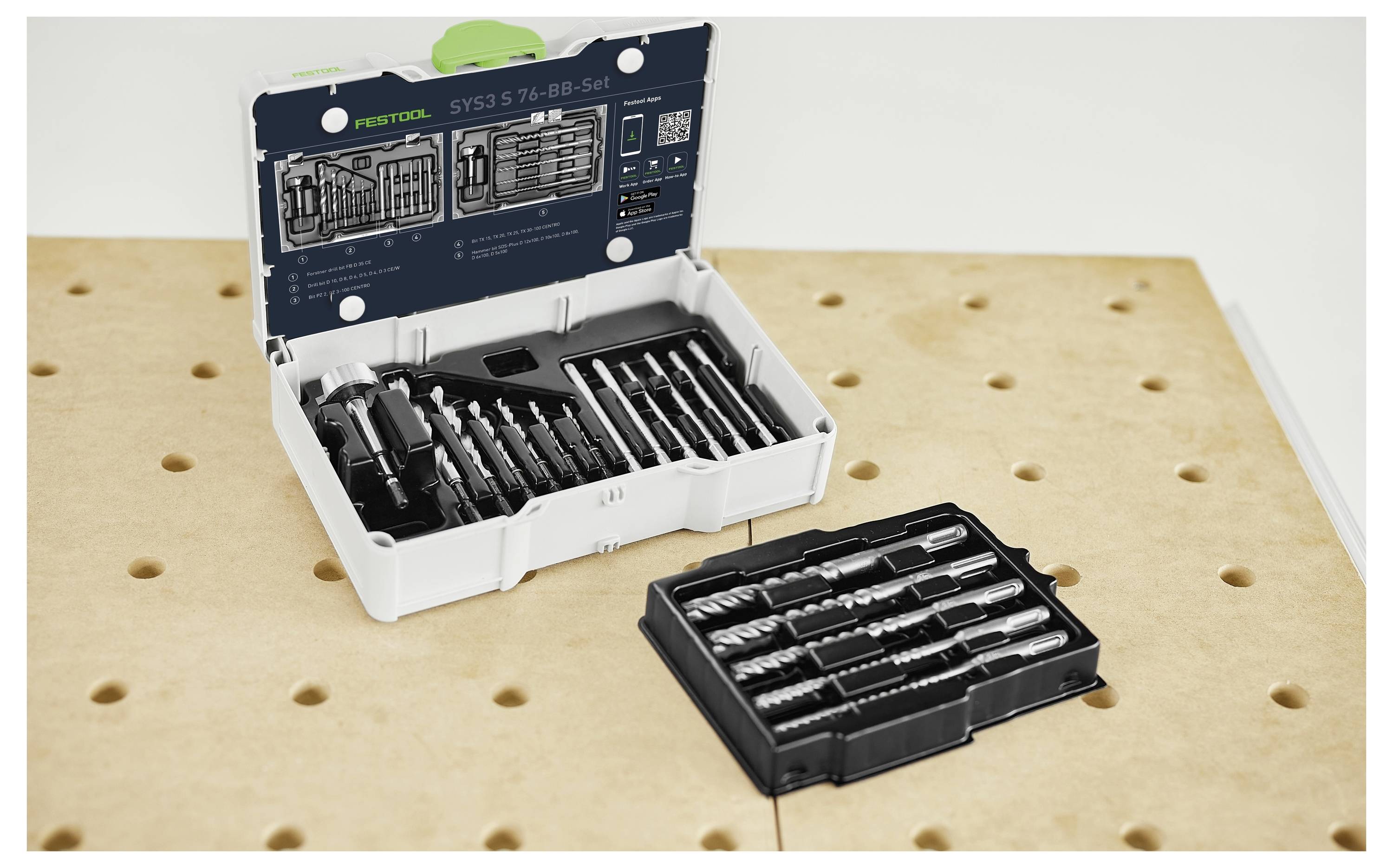 Ein offener Koffer mit verschiedenen Bohrern, die ordentlich angeordnet sind, auf einer gelöcherten Holzplatte platziert.