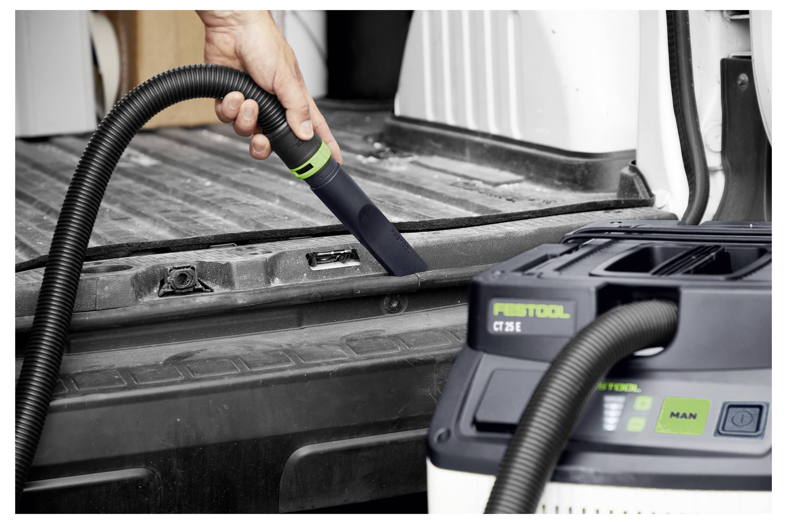 Ein Mann in Schutzausrüstung verwendet ein Elektrowerkzeug zum Schneiden von Metall, wobei Funken fliegen, in einer industriellen Umgebung.